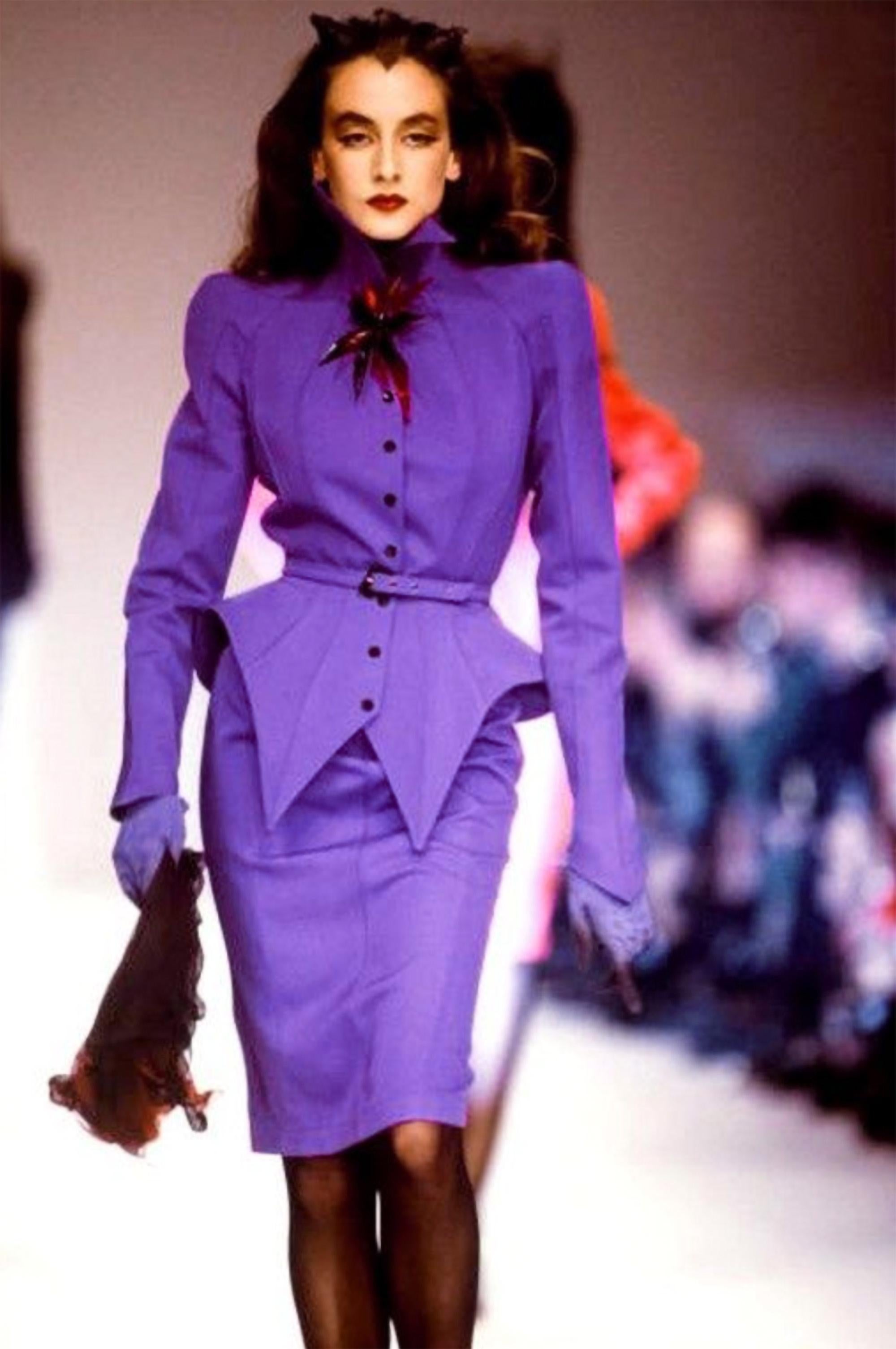 Une pièce d'histoire de la mode digne d'un musée

Le célèbre tailleur jupe violet/violet de la Collection Mugler LES INFERNALES FW 1988/ 1989. Ensemble deux pièces, veste et jupe.
Fantastique pièce oconique signée Thierry Mugler !
Très bien