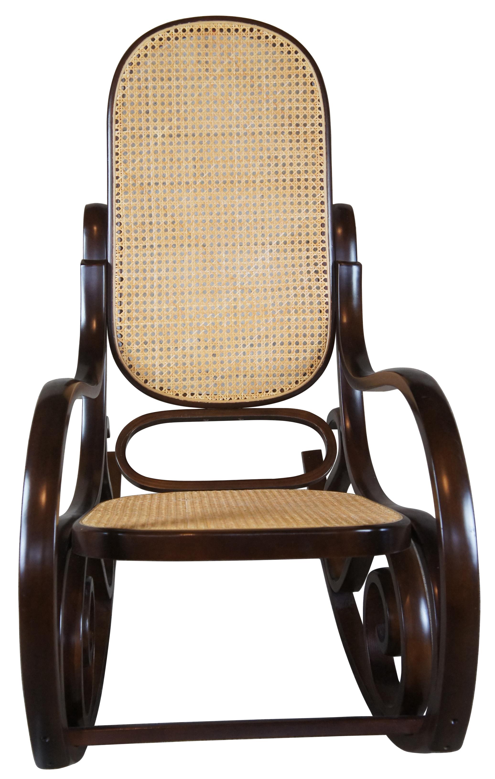 Thonet style attributed rocking chair. Circa mid century. Made from hardwood in classic bentwood styling with rattan back and seat. 
 