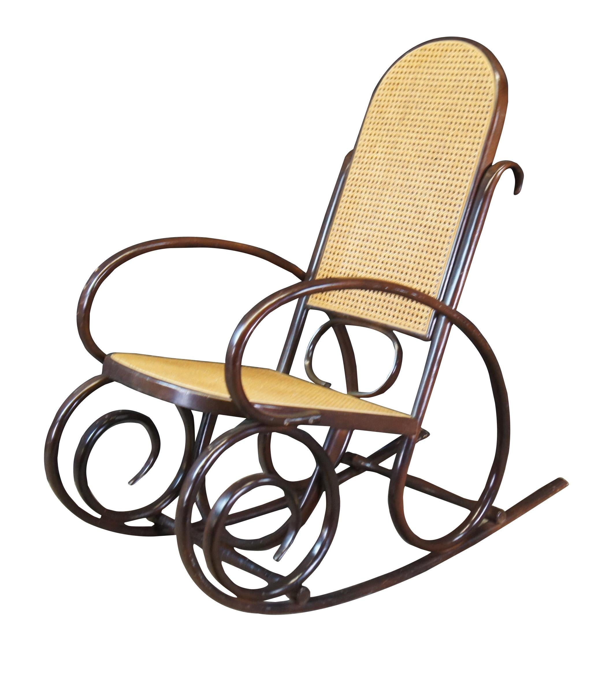 Thonet style attributed rocking chair. Circa mid century.  Made from hardwood in classic bentwood styling with rattan back and seat.  

Dimensions:
40