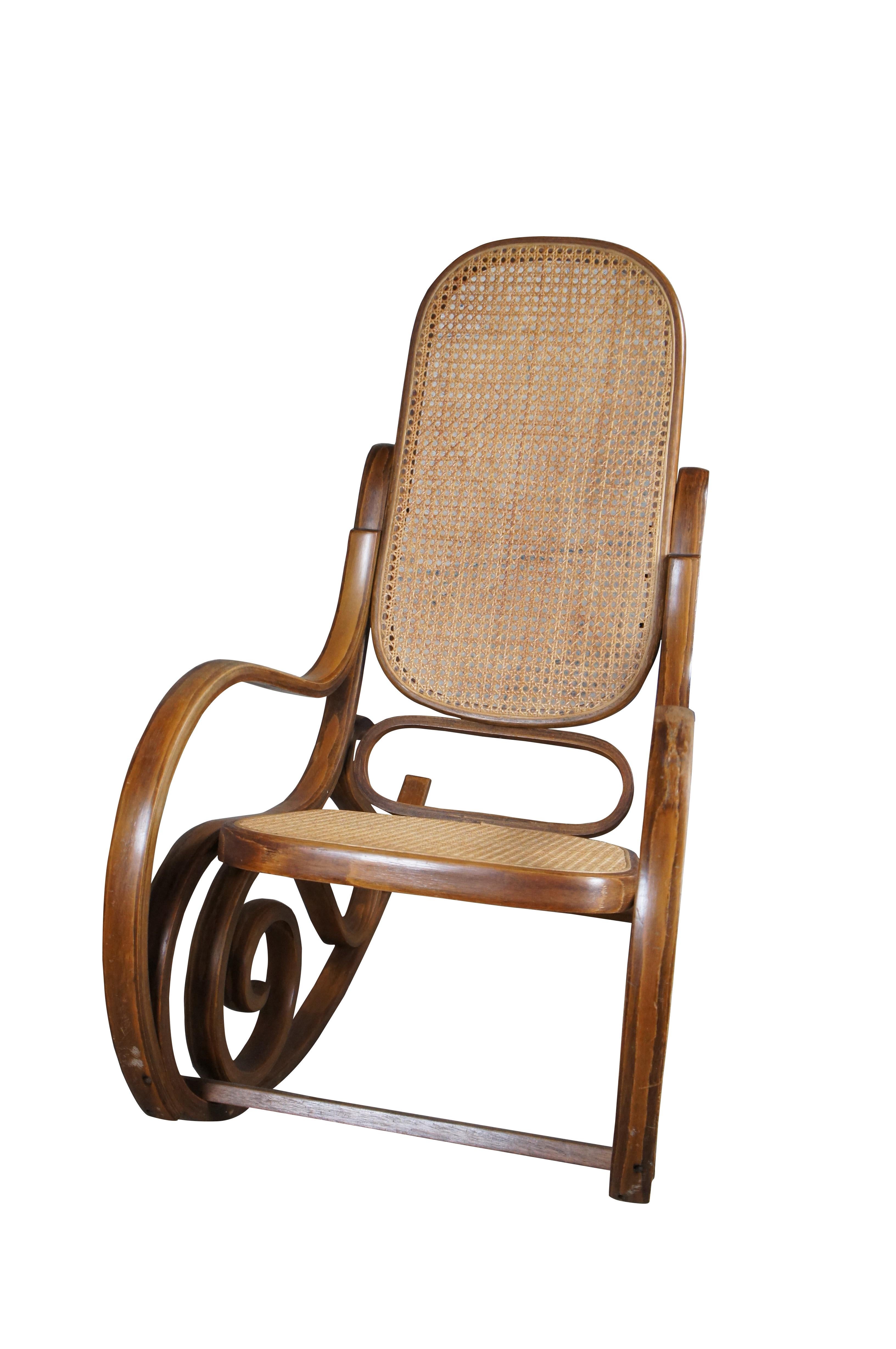 Sedia a dondolo in legno di bengala, circa metà del XX secolo. Realizzata in noce in stile classico bentwood con schienale e seduta in rattan.

Dimensioni:
41.5