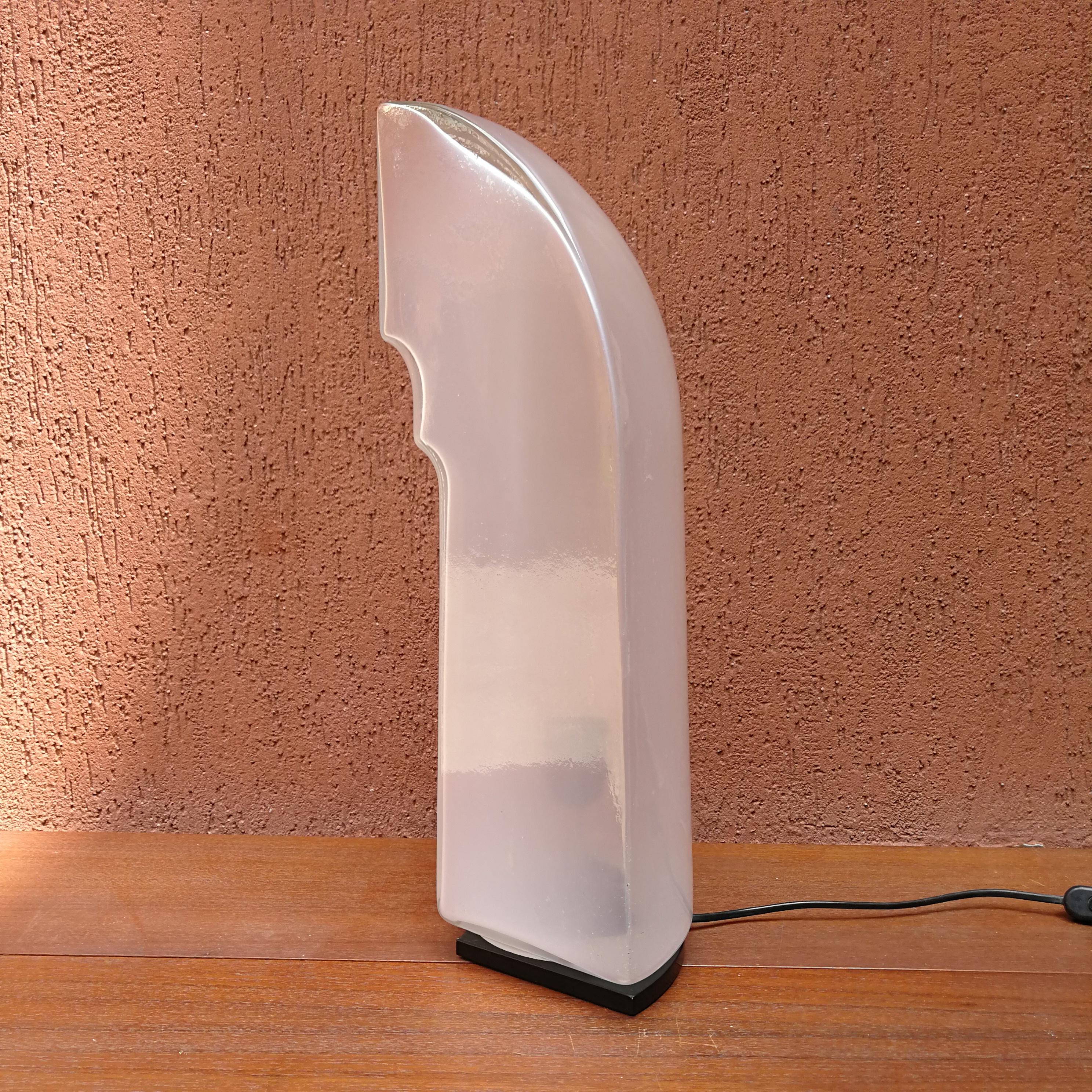 Stunning Tiki table lamp by the Japanese Takahama for the Italian maker Leucos, from 1980s.
A sculptural Murano glass shade sits on a black foot giving it a distant resemblance of a penguin.
You can switch it on or off, but it remains amazingly