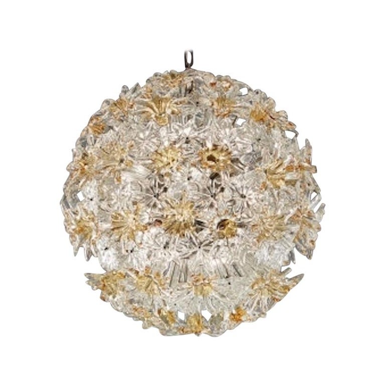 Questo straordinario lampadario esprit è stato prodotto da Venini negli anni Settanta.
Esplosione di fiori, realizzata con preziosi vetri di Murano color ambra e trasparenti.
Telaio e ferramenta cromati. Disponibile anche la catena su