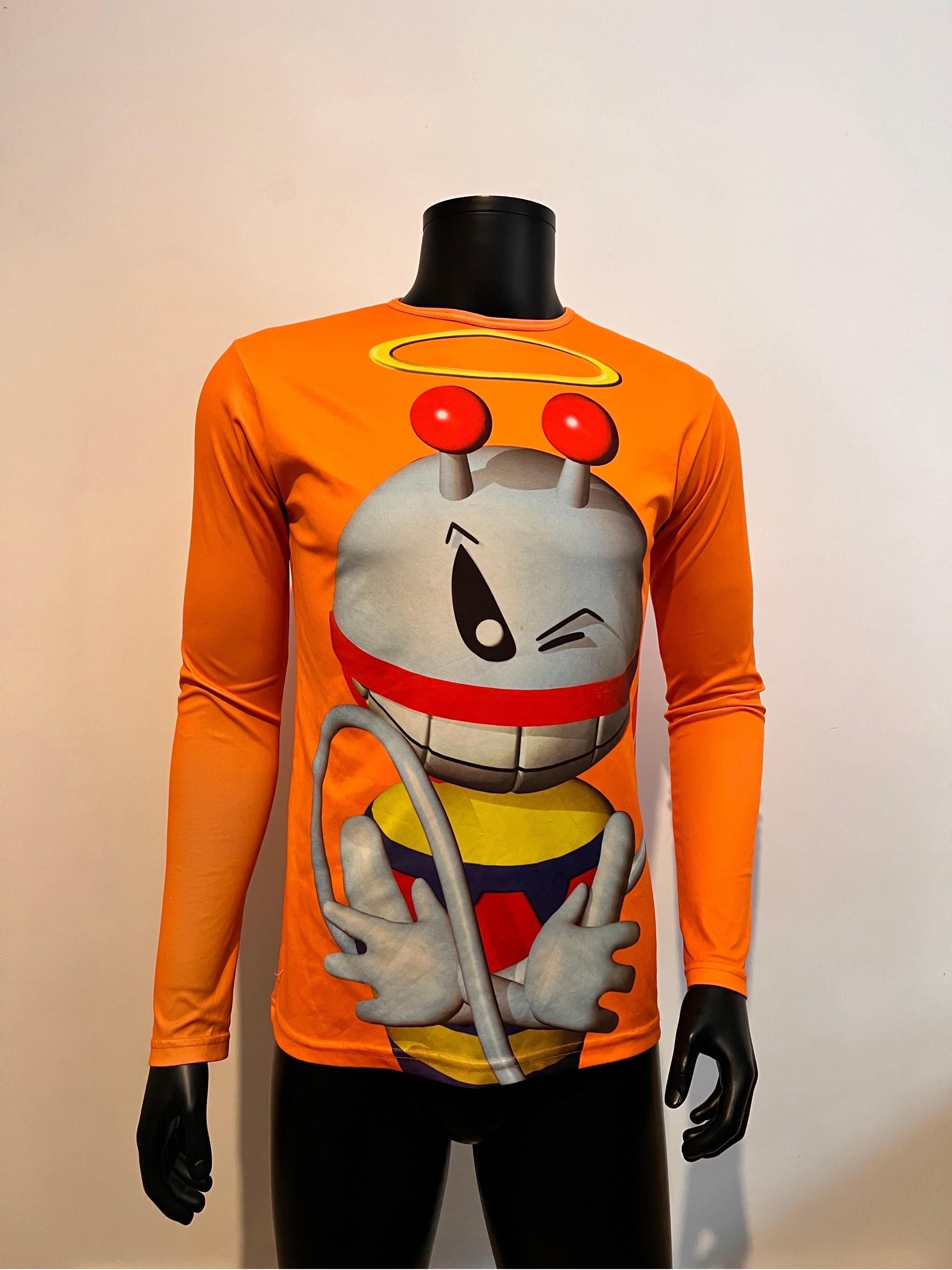 Iconic W< (Wild & Lethal Trash) by Walter Van Beirendonck long sleeve tee shirt in a bright orange featuring the 3d black rubber tag and a bold 3d render of the brands mascot Puk Puk! The set also includes an over layer short sleeved tee shirt