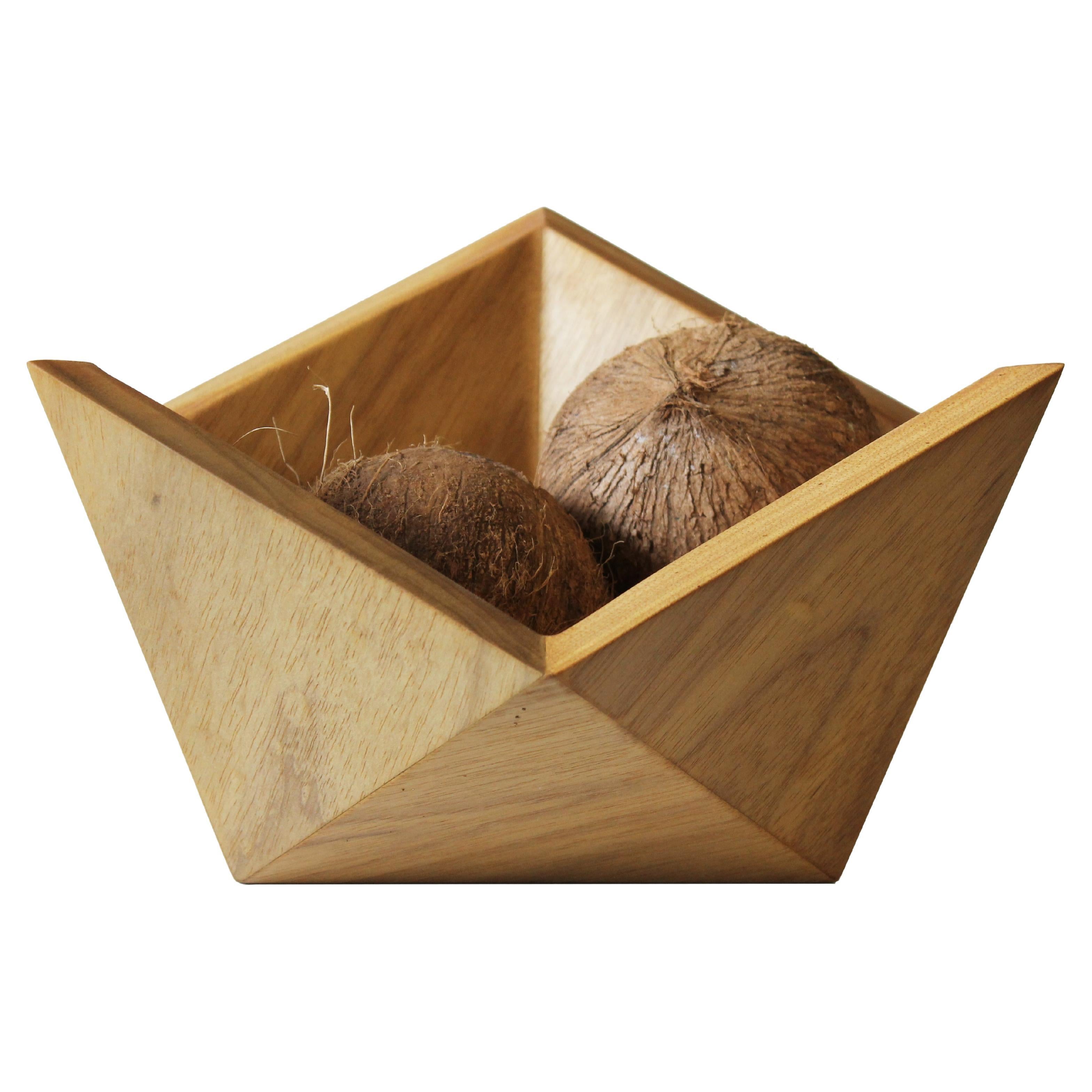 Its shape derives from the half of an icosahedron, resulting in a sculptural object with a good storage area. It is supported on the table by the center point or by the sides, in a dynamic position. Due to the shape, it is also possible to make