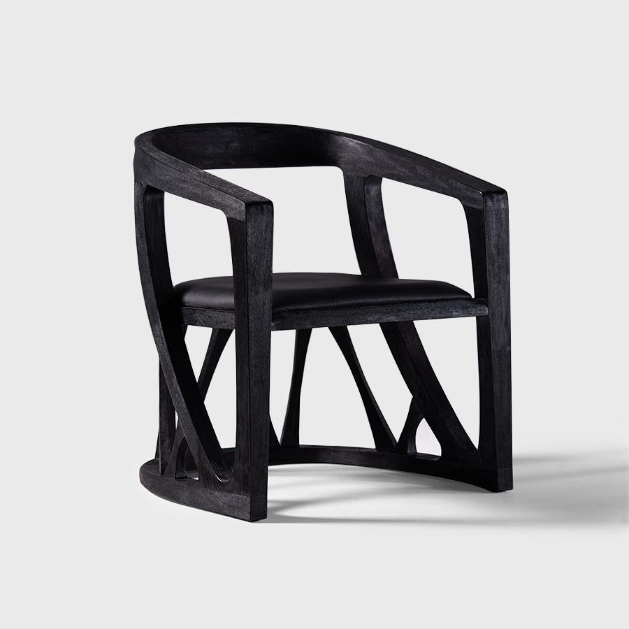 A contemporary reinterpretation of the iconic Mexican equipal. Crafted from solid black-stained wood, its sculpted structure combines organic lines with geometric precision, embracing an upholstered black leather seat that adds depth and