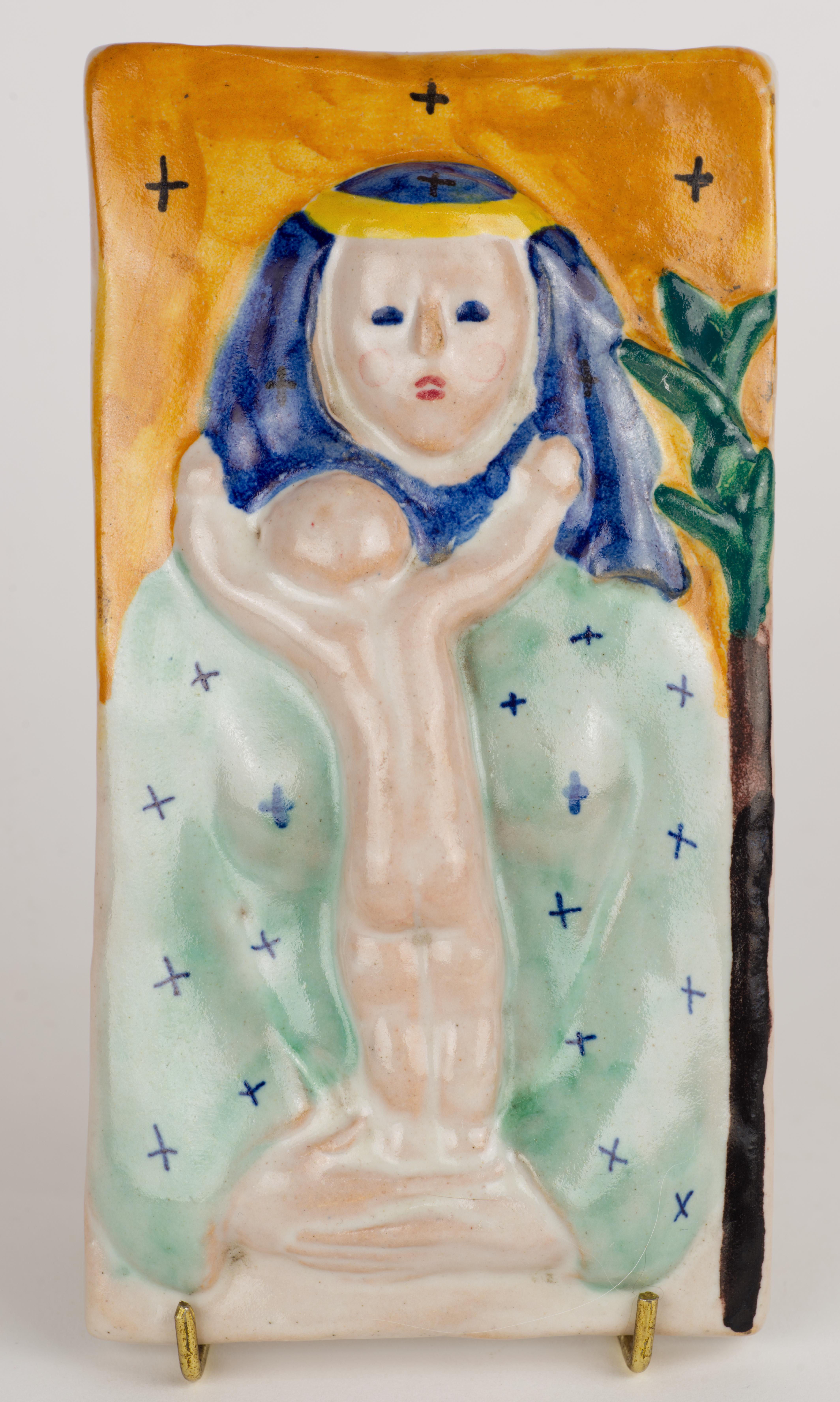  Affascinante targa decorativa d'epoca raffigurante madre e figlio, probabilmente Madonna & Child, realizzata in rilievo e decorata con smalti in maiolica. Gli smalti blu e verde acqua, utilizzati per il vestito e il copricapo, contrastano
