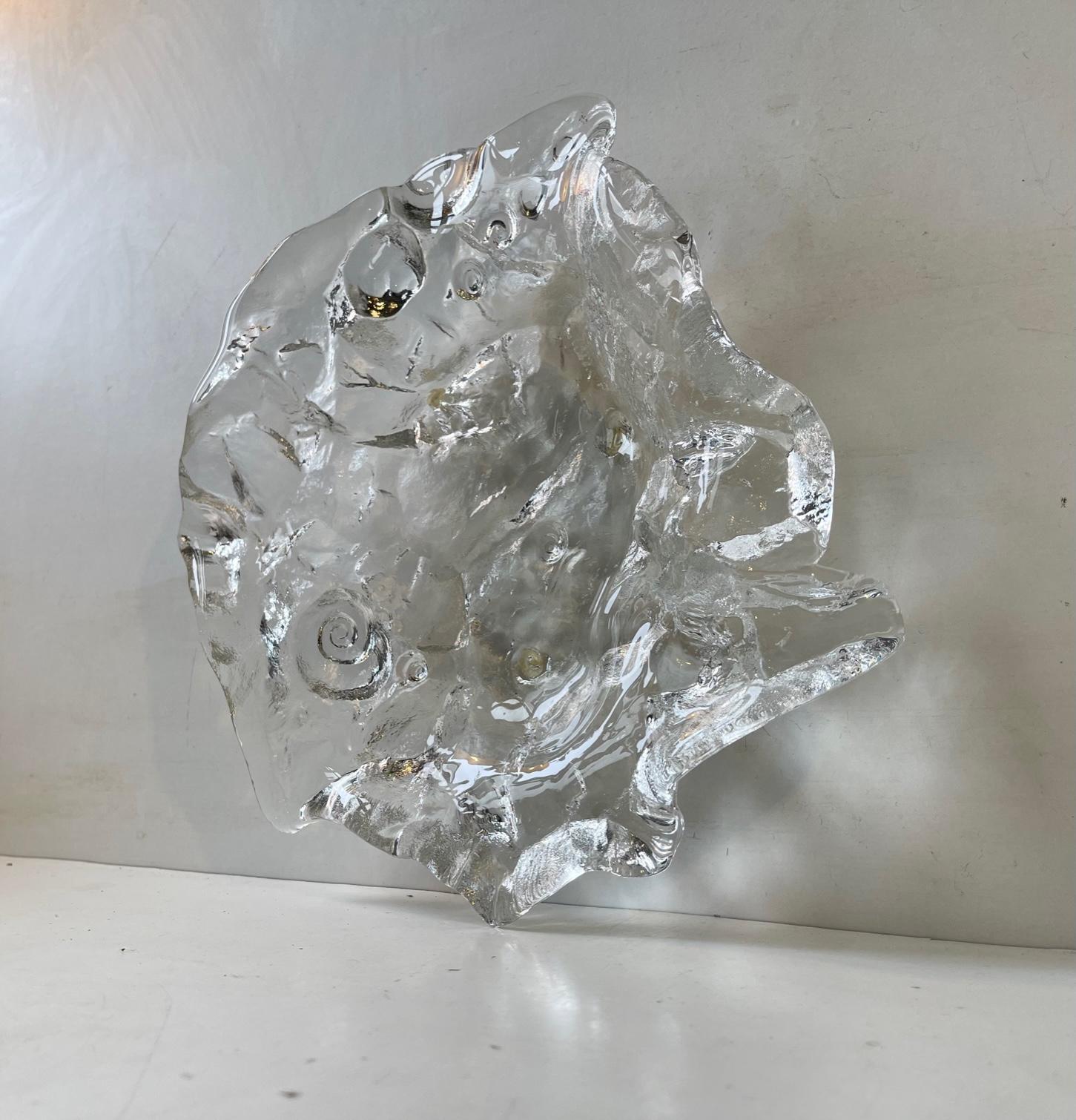 From certain angles it looks like a face in profile. But this heavy stock freeform dish or centerpiece bowl actually mimics ice with incapsulated shells. Designed and made by Pukeberg in Sweden circa 1970 in a style reminiscent of René Lalique.