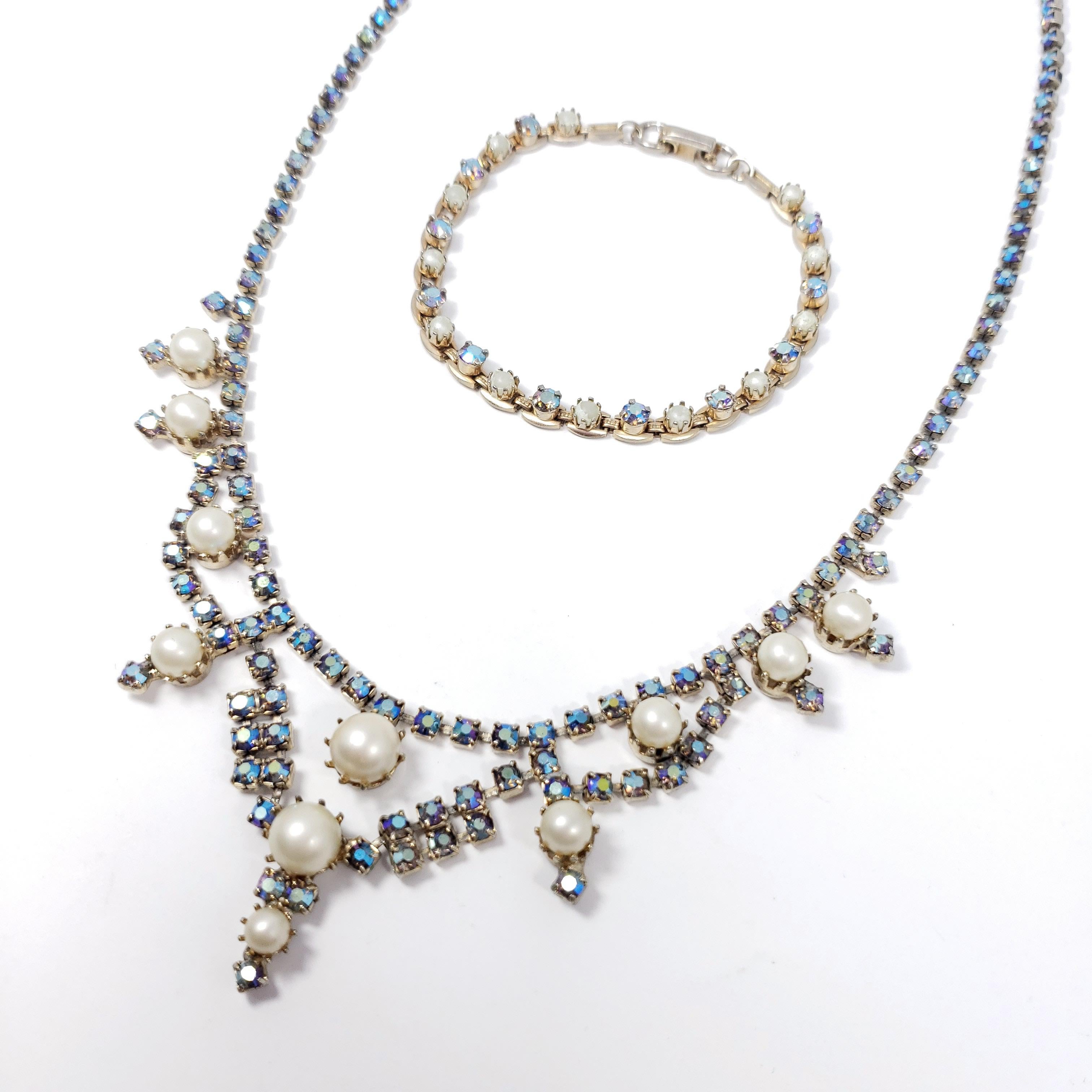 Des cristaux d'aurore boréale bleu glacé et de fausses perles sont sertis sur cette paire de collier et bracelet vintage.

Tonalité argentée.

Vers les années 1950.

Collier : 16 pouces
Bracelet : 7 pouces