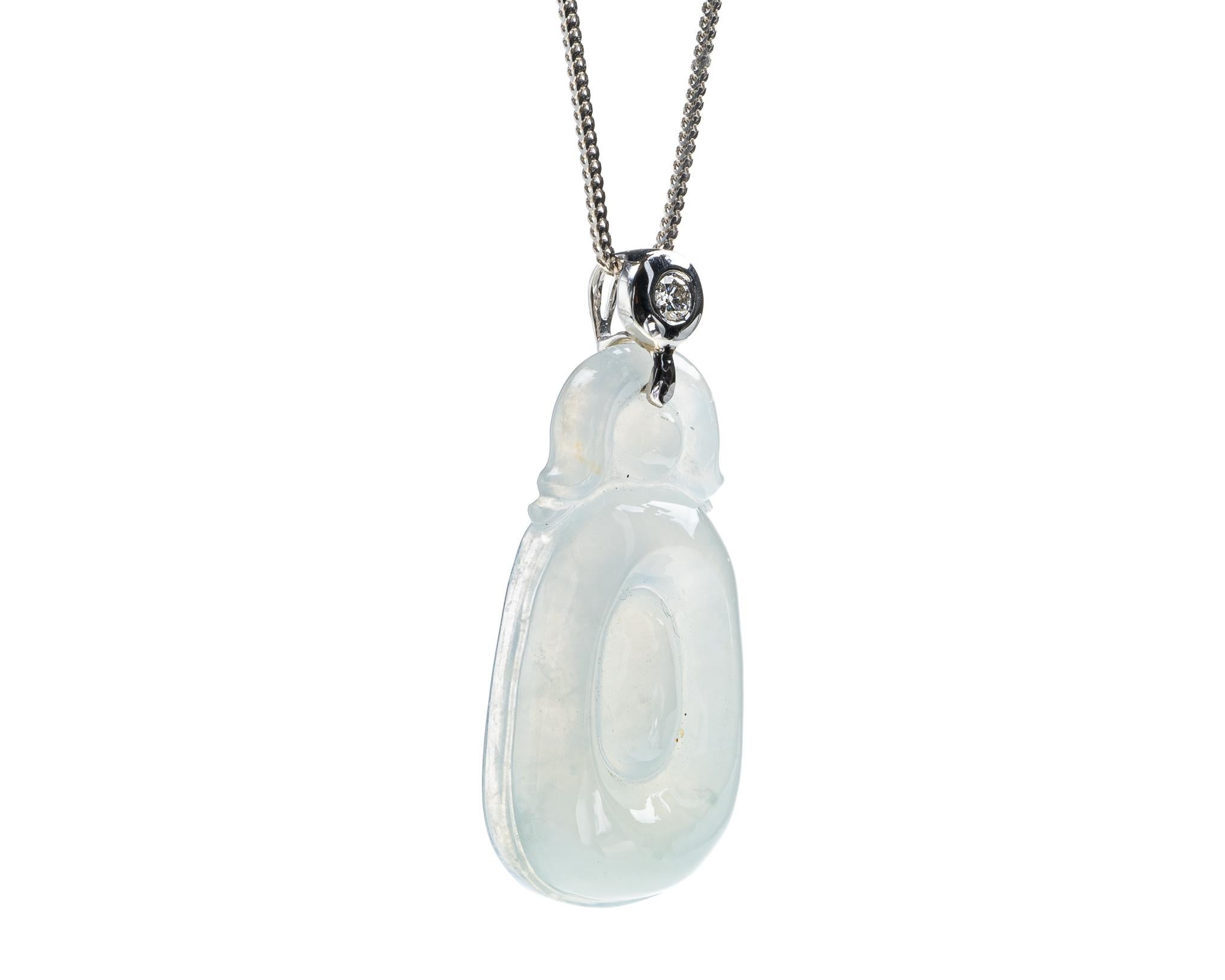 This is an all natural, untreated jadeite jade carved gold coin and diamond pendant set on an 18K white gold and diamond bail.  The carved gold coin symbolizes wealth and prosperity\
.   
It measures 1.52 inches (38.7 mm) x 0.67 inches (17.2 mm)
