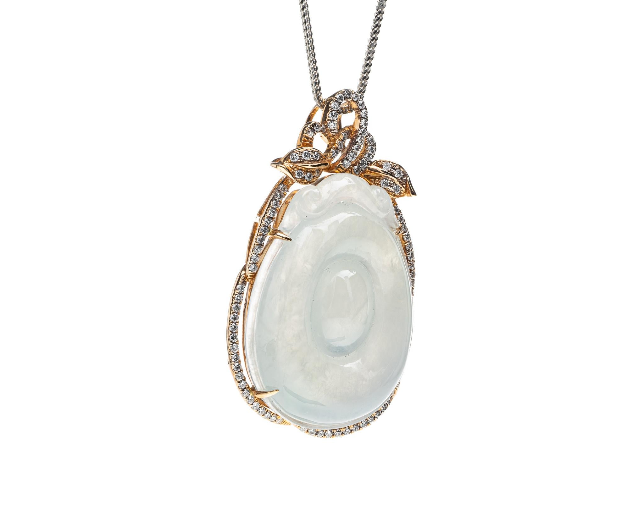 This is an all natural, untreated jadeite jade carved gold coin and diamond pendant set on an 18K rose gold and diamond bail.  The carved gold coin symbolizes wealth and prosperity.
.   
It measures 1.73 inches (44 mm) x 1.01 inches (25.9 mm) with