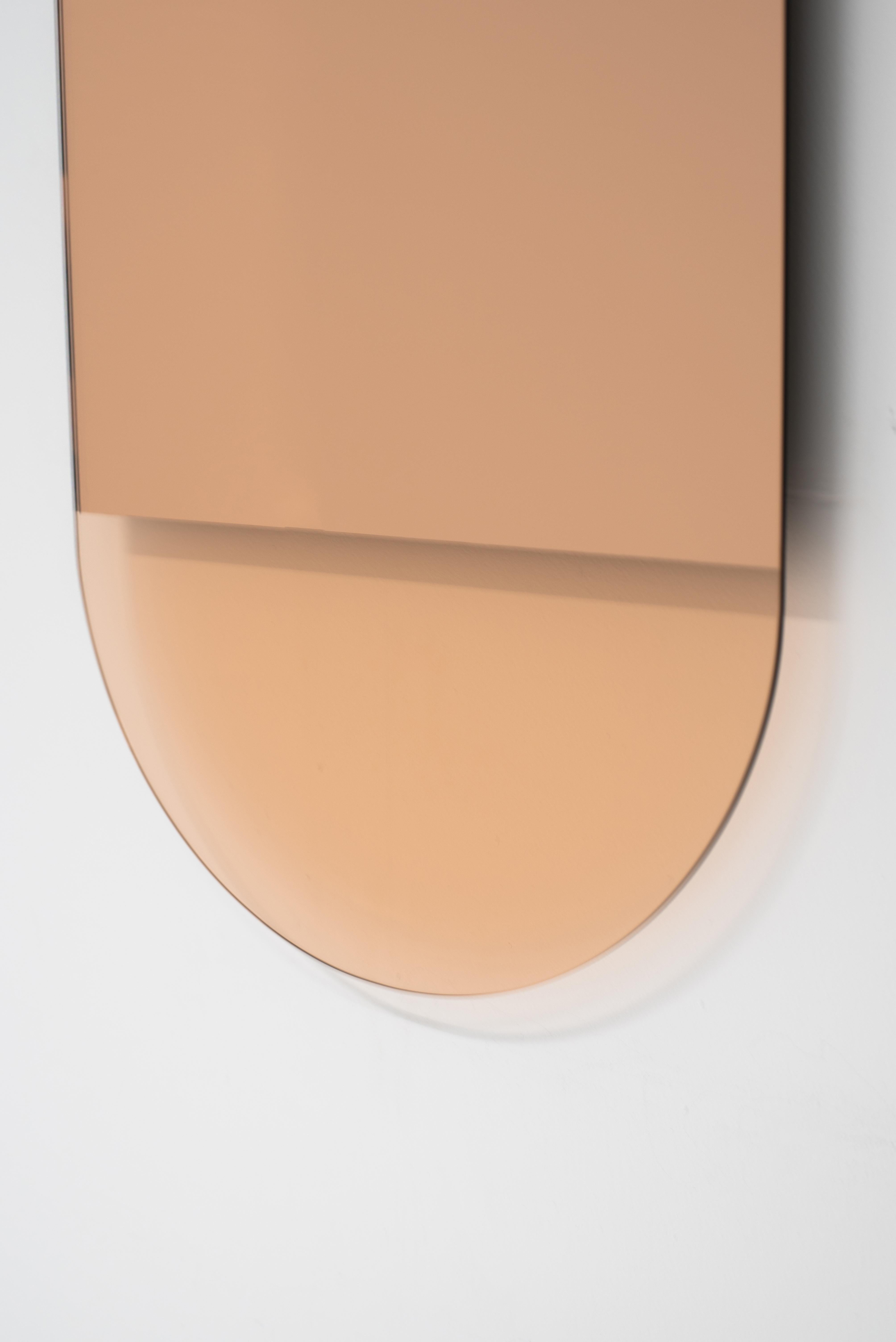 The IDA No. 3 mirror by Ben and Aja Blanc, pairs a Minimalist form with mirror removal to create formal and tonal shifts in this vertical mirror. The warm rose gold colors come from peach mirror and glass creating piece that is both stunning and