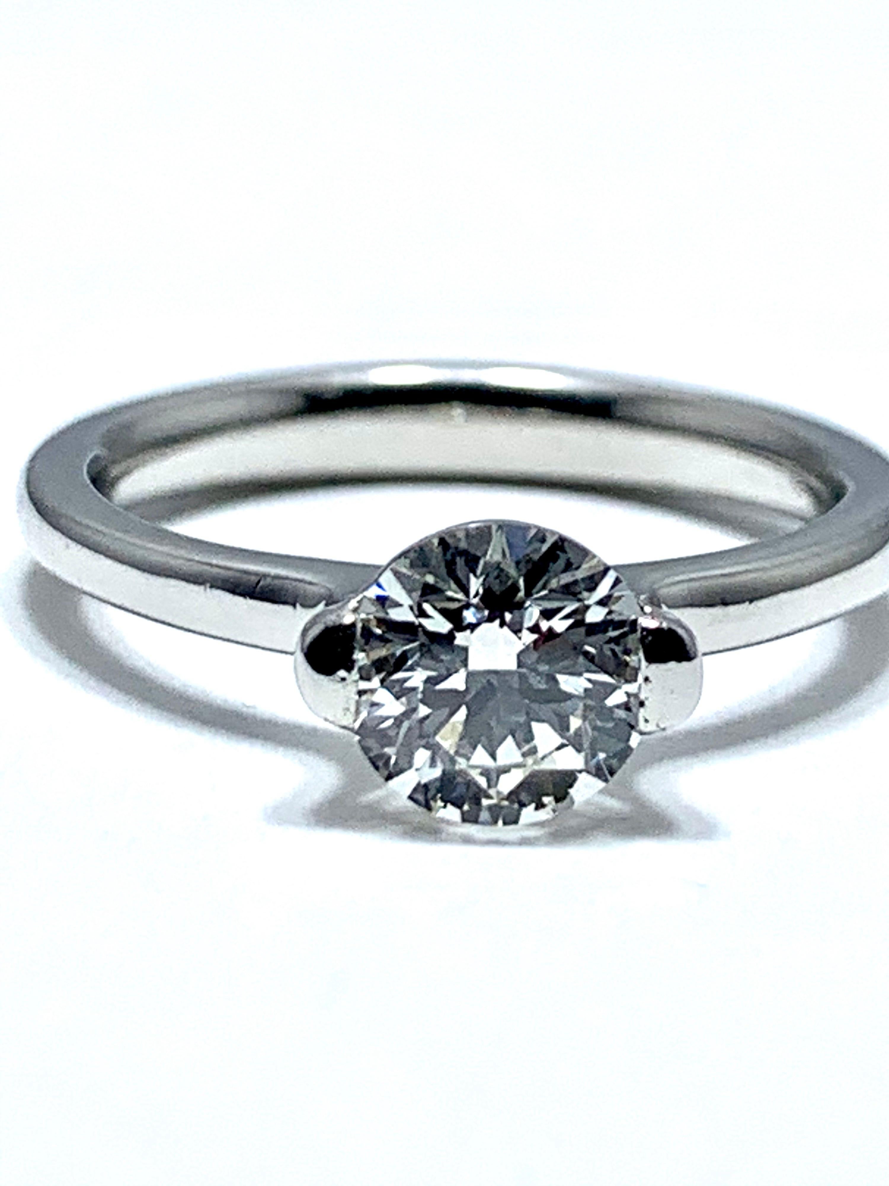 This diamond is fire!  A 0.84 carat Ideal cut round brilliant diamond solitaire in a platinum setting.  The diamond is set with two large prongs sitting above the polished shank of the ring.  The diamond is graded by AGS laboratories as ideal cut,