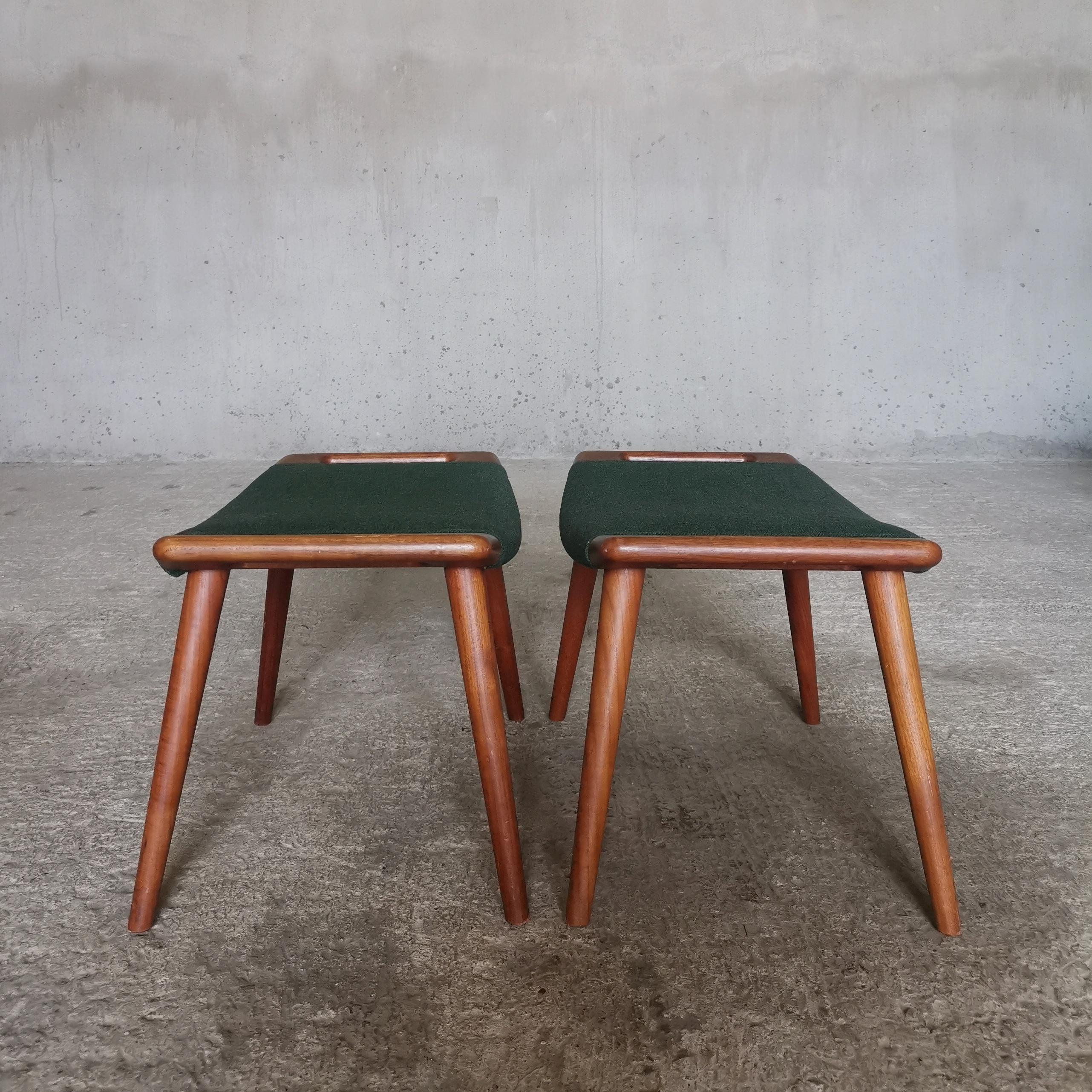 This pair of identical Papa Bear Ottomans AP-29 by Hans J. Wegner for A. P. Stolen, Denmark 1950s were acquired directly from the children of the original owner. 
Both ottomans have been preserved with the original seats in green wool kept in mint