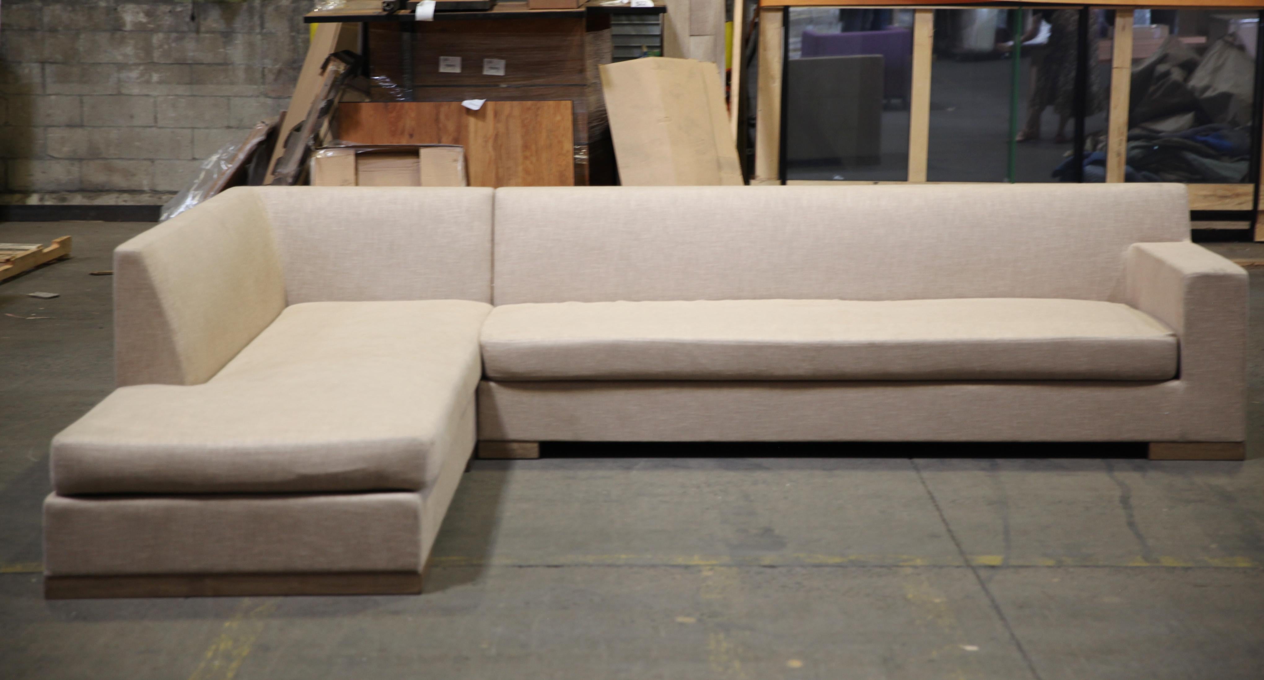 Modern Minimalist style large sectional sofa designed by Ideo. The piece comes in two sections, one with an ottoman side. Accompanied by a set of nine throw pillows, this sectional sofa is in great vintage condition with age-appropriate wear and use