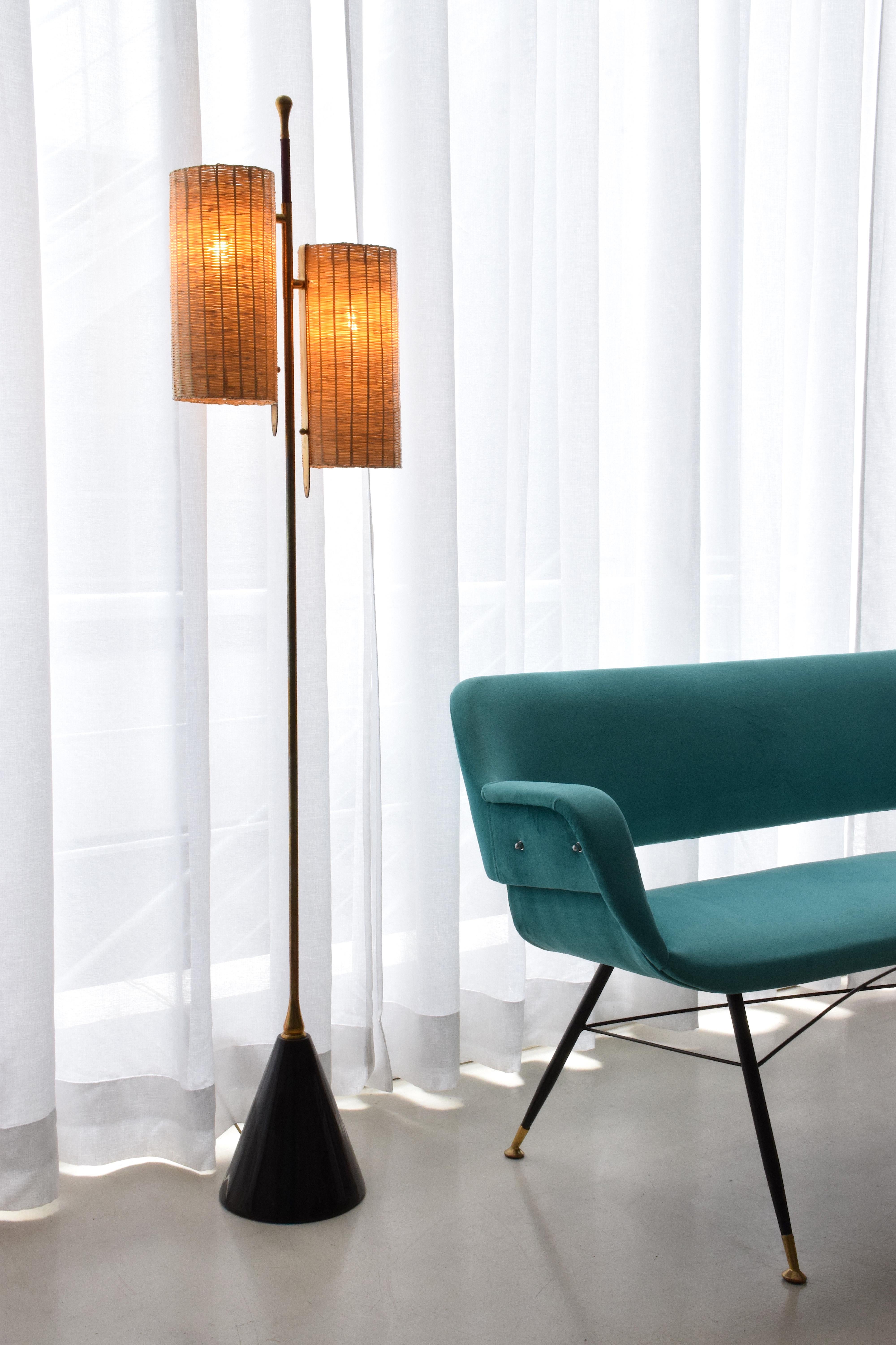 A medium-sized light composed of a solid brass stand adorned with a leather sheathed detail at the top. The long cylinder shades are available in hand-woven wicker or fabric. Option to choose between a black, white or green marble base.

2x60 W Max