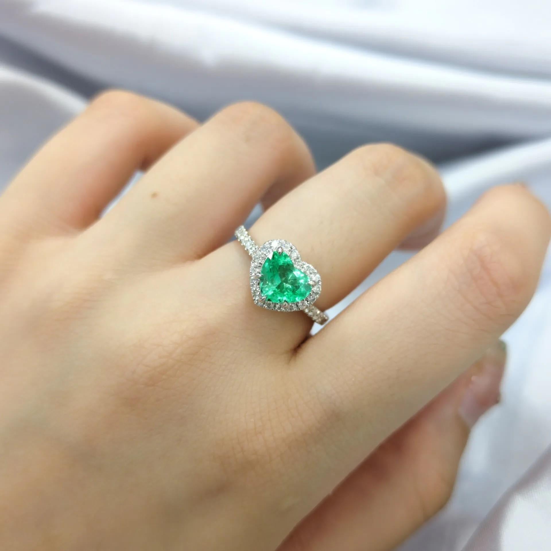 This enchanting ring showcases a 0.97-carat heart-shaped mixed cut emerald, a gem that embodies both romance and vibrant beauty, originating from the esteemed mines of Colombia.  Colombian emeralds are celebrated worldwide for their intense green