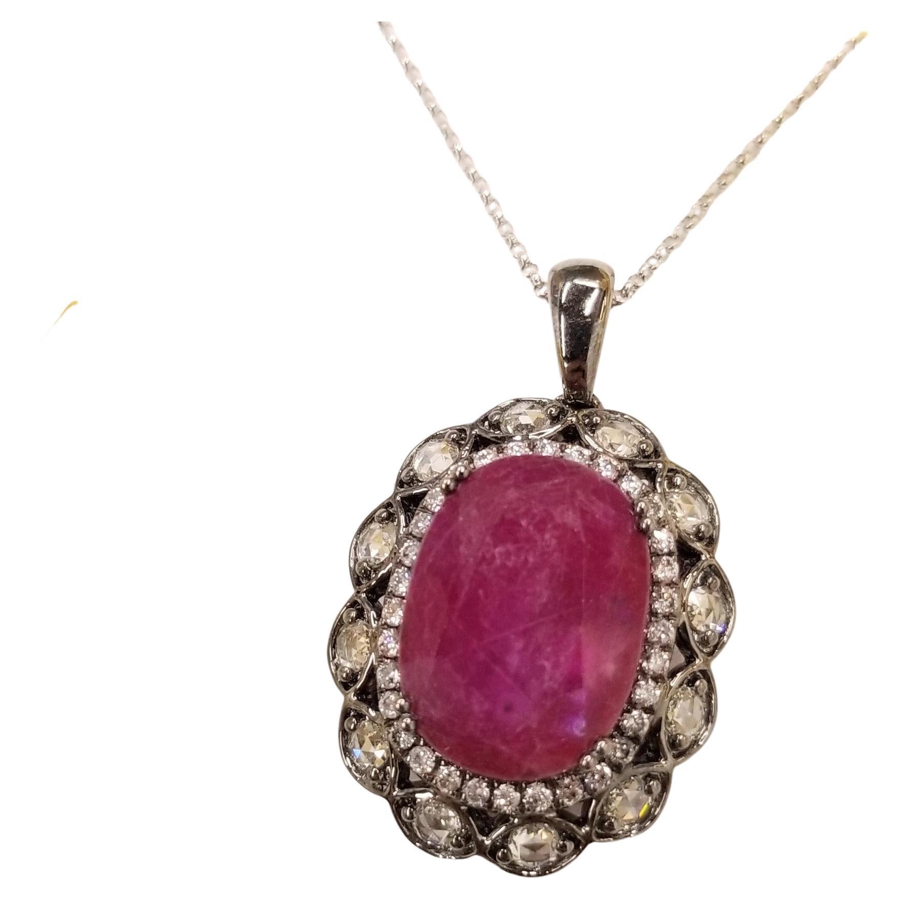 Collectible unique black gold ruby pendent.
The ruby weighs an impressive 10.30carat and has a beautiful oval shape along with an deep purlish-red color that makes it so special. It is complemented by 1.11  carats of round brilliant-cut & rose-cut