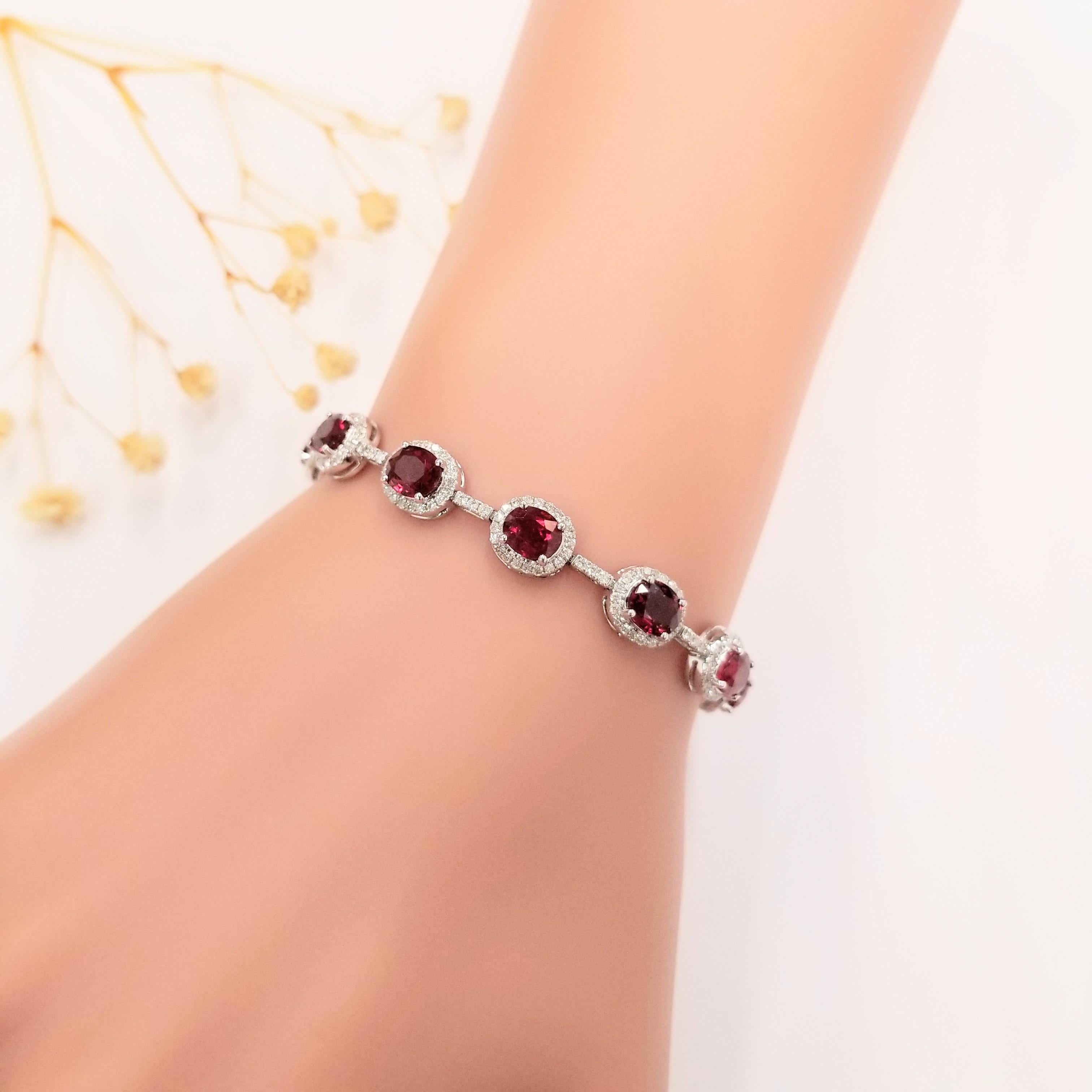 Introducing the dazzling IGI Certified 10.55 Ct Ruby & Diamond Bracelet in 18K Gold. This breathtaking piece features exquisite oval-shaped rubies, originating from Mozambique, elegantly encased in diamond halos. Connected by a diamond bar, this