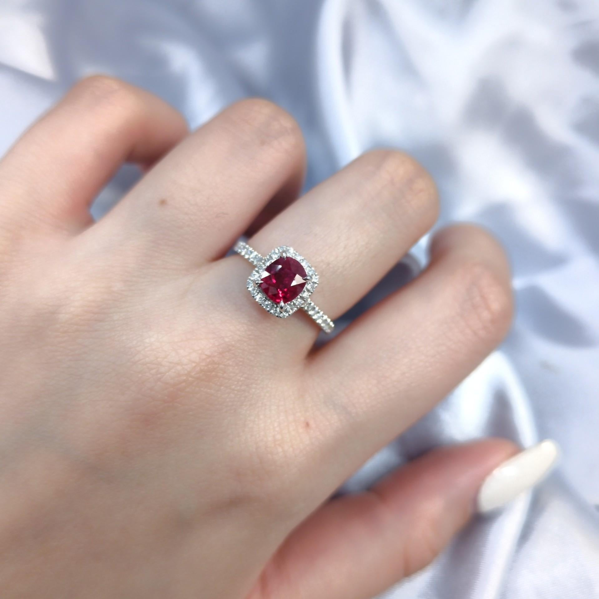 Unveil the brilliance of this stunning 18K white gold ring, a testament to timeless elegance and vibrant color.  At its heart lies a captivating 1.07 carat oval mixed cut ruby, boasting a Vivid Red hue that radiates passion and sophistication. 