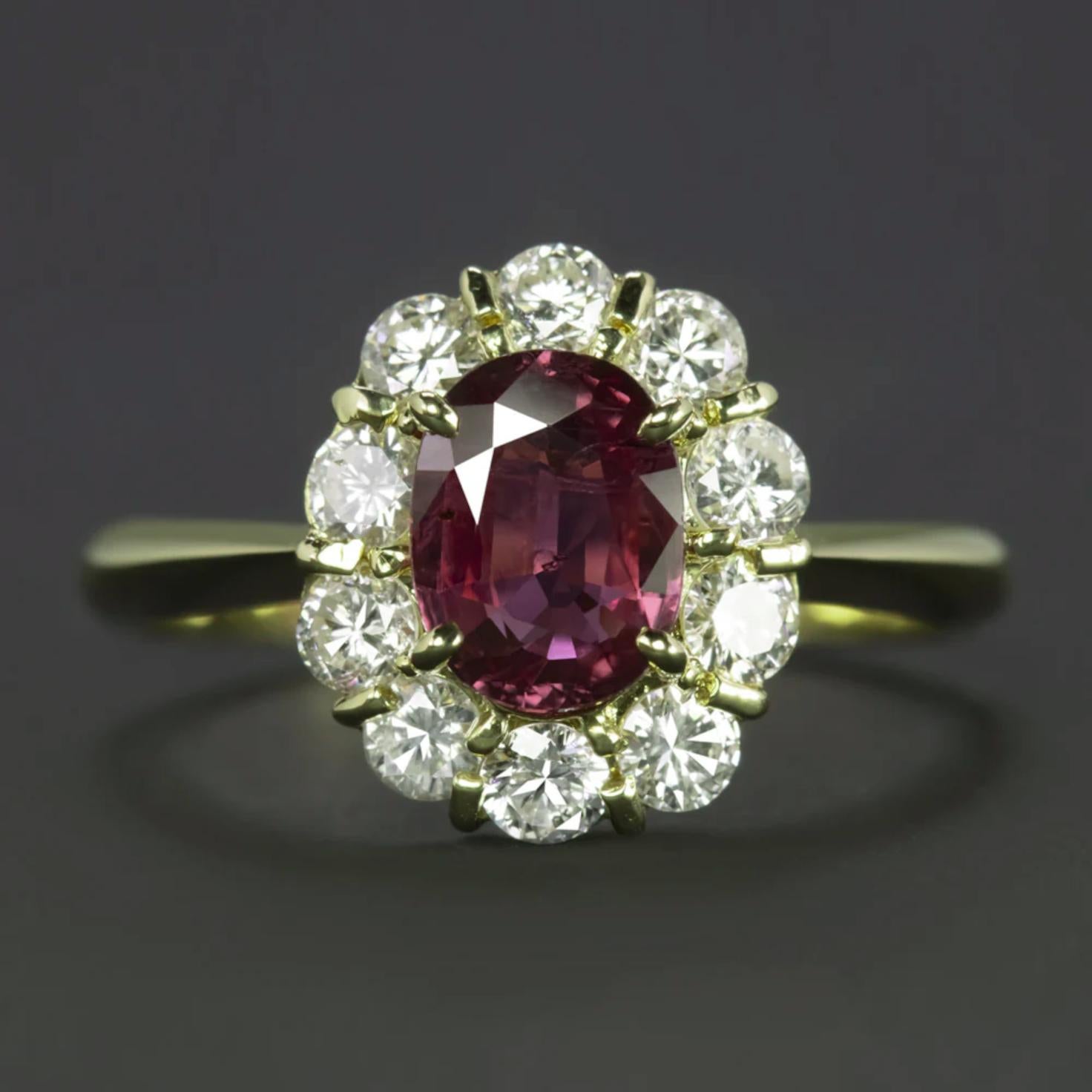 Crafted with precision and grace, this luxurious ring features a mesmerizing 1.08 carat natural oval mixed cut ruby, set at the center of a stunning halo of round brilliant diamonds. This exceptional ruby, certified by the International Gemological