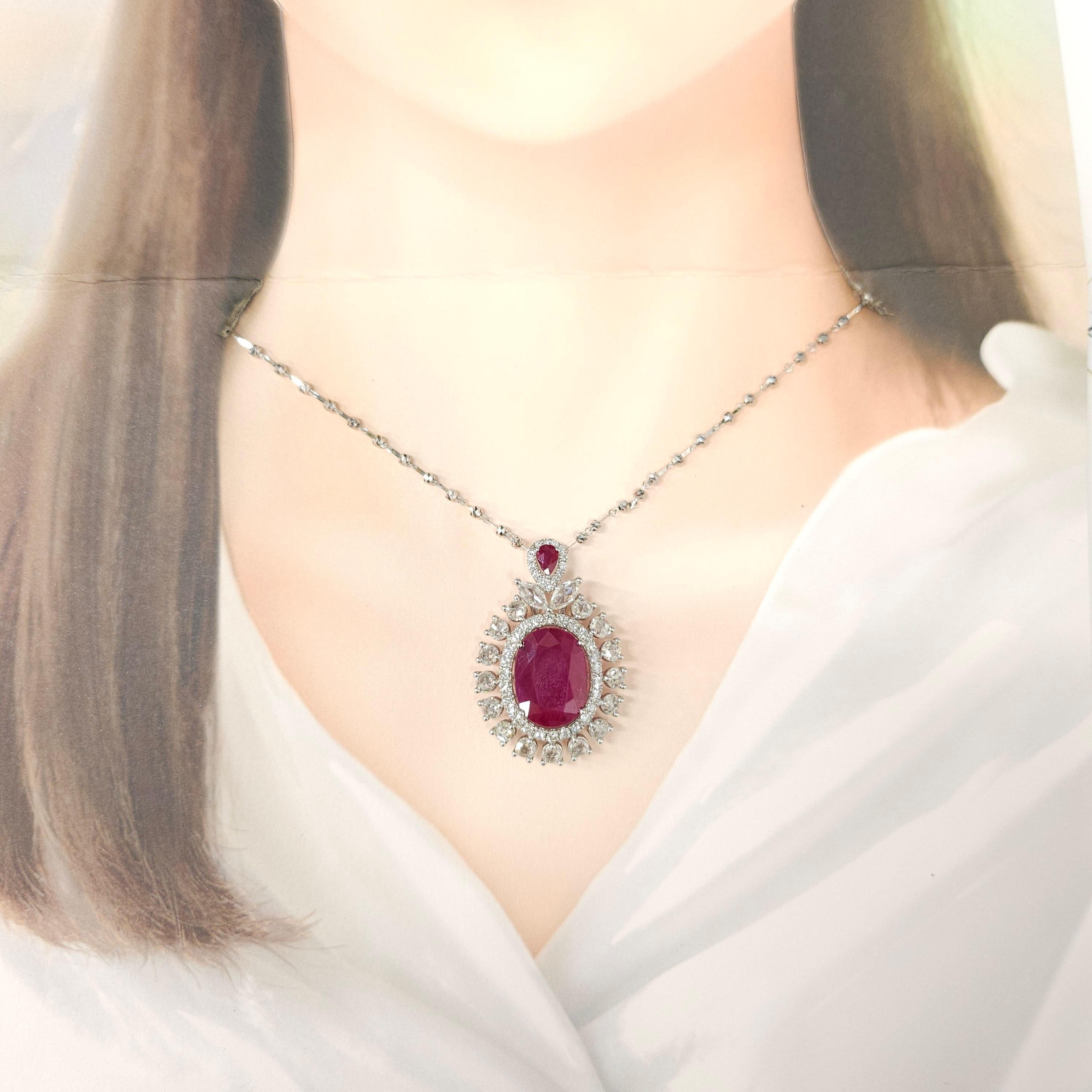 Prepare to be captivated by the allure of this IGI Certified 11.03 Carat natural Ruby pendant, showcasing a captivating intense purplish-red color in a captivating oval shape. Set against the backdrop of lustrous 18K white gold, this pendant is a