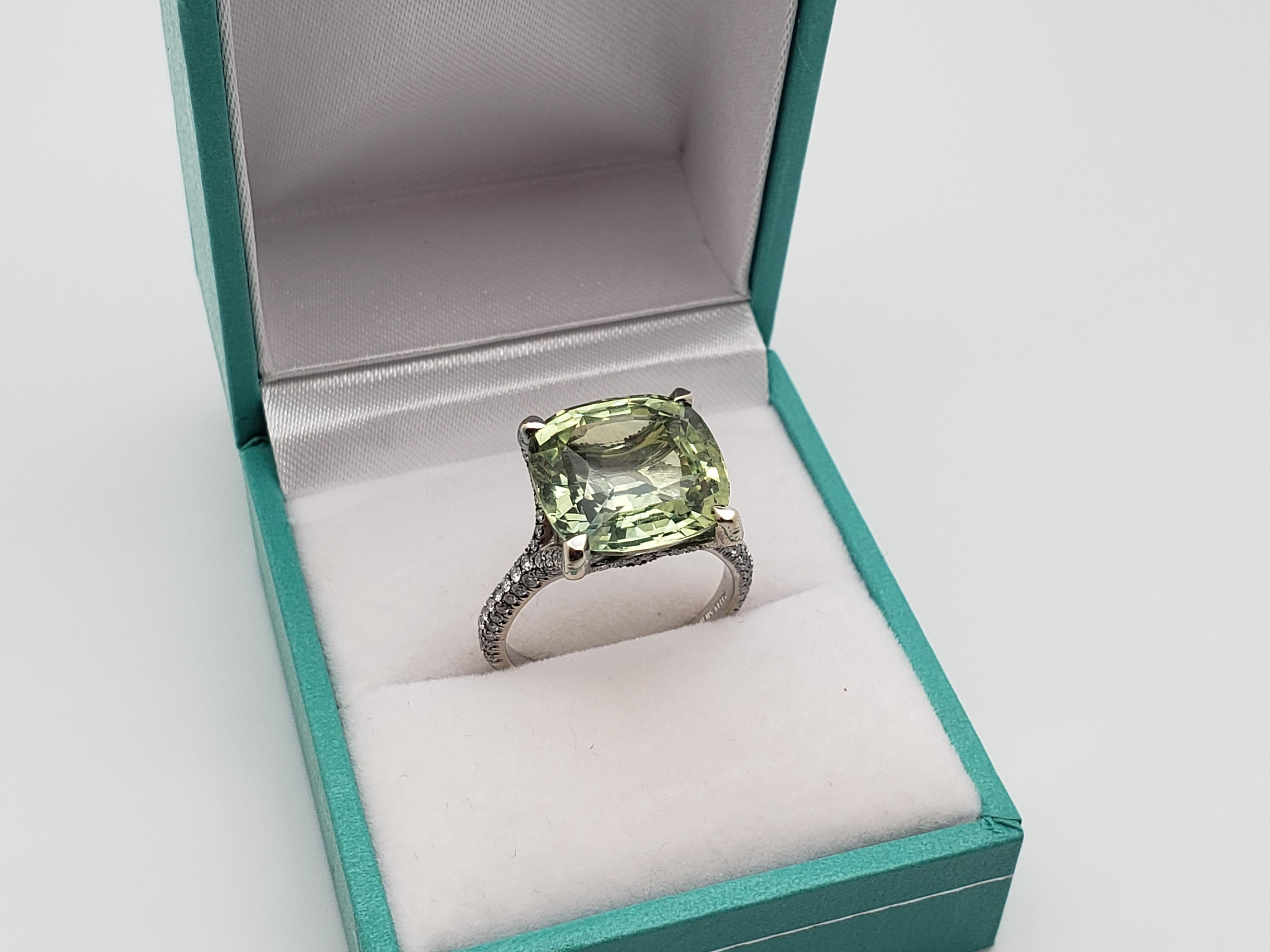 Uno straordinario anello Irina Ferry in oro bianco 18 carati con zaffiri verdi naturali e diamanti, certificato IGI. Al centro uno zaffiro verde foresta naturale con taglio a cuscino, del peso di circa 11,63 CT e delle dimensioni di 13,04 x 12,98 x