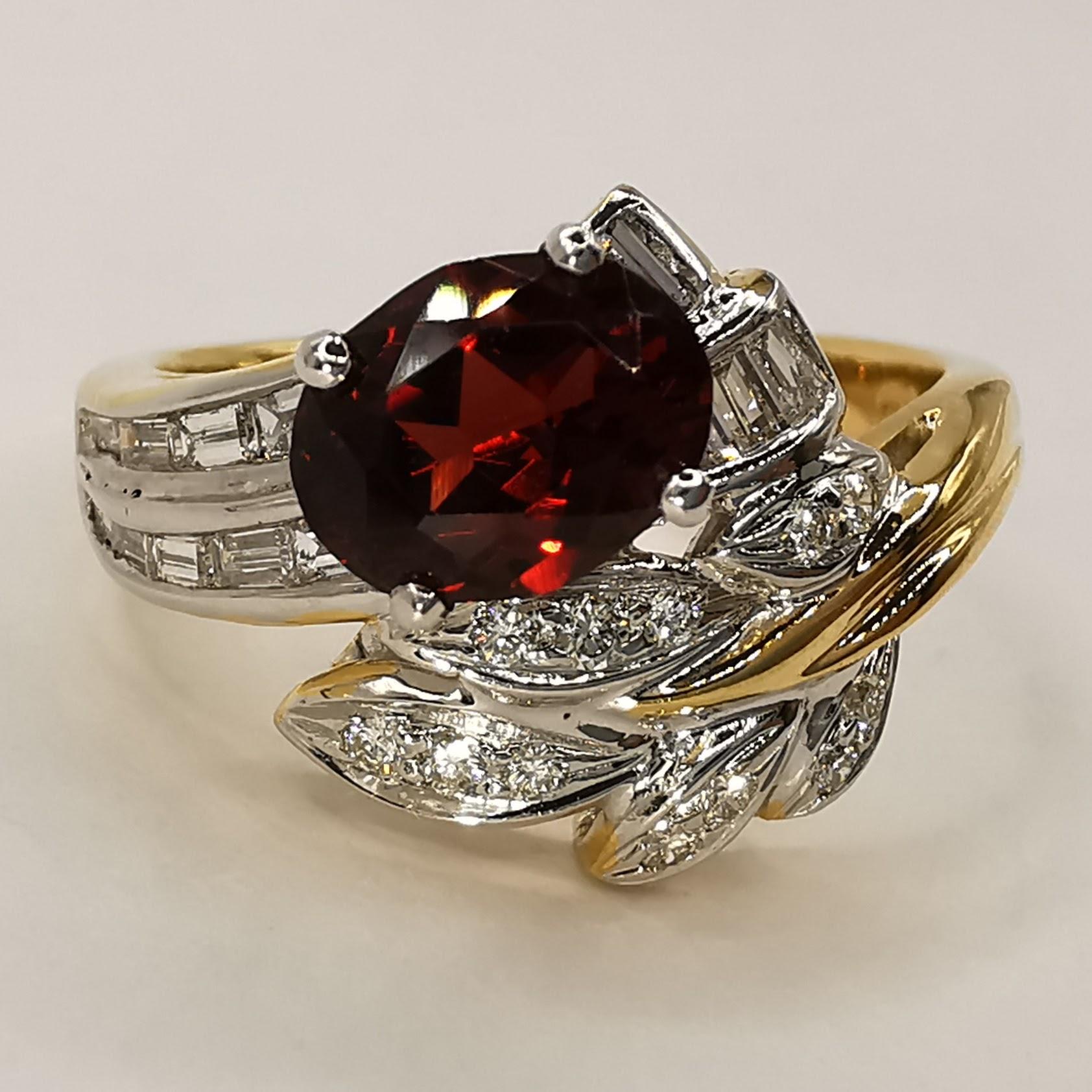 This IGI certified natural oval orangy red garnet diamond ring in yellow gold is a stunning piece of jewelry that is sure to turn heads. The centerpiece of the ring is a beautiful 1.21 carat natural oval cut deep orangy red pyrope-almandite garnet.