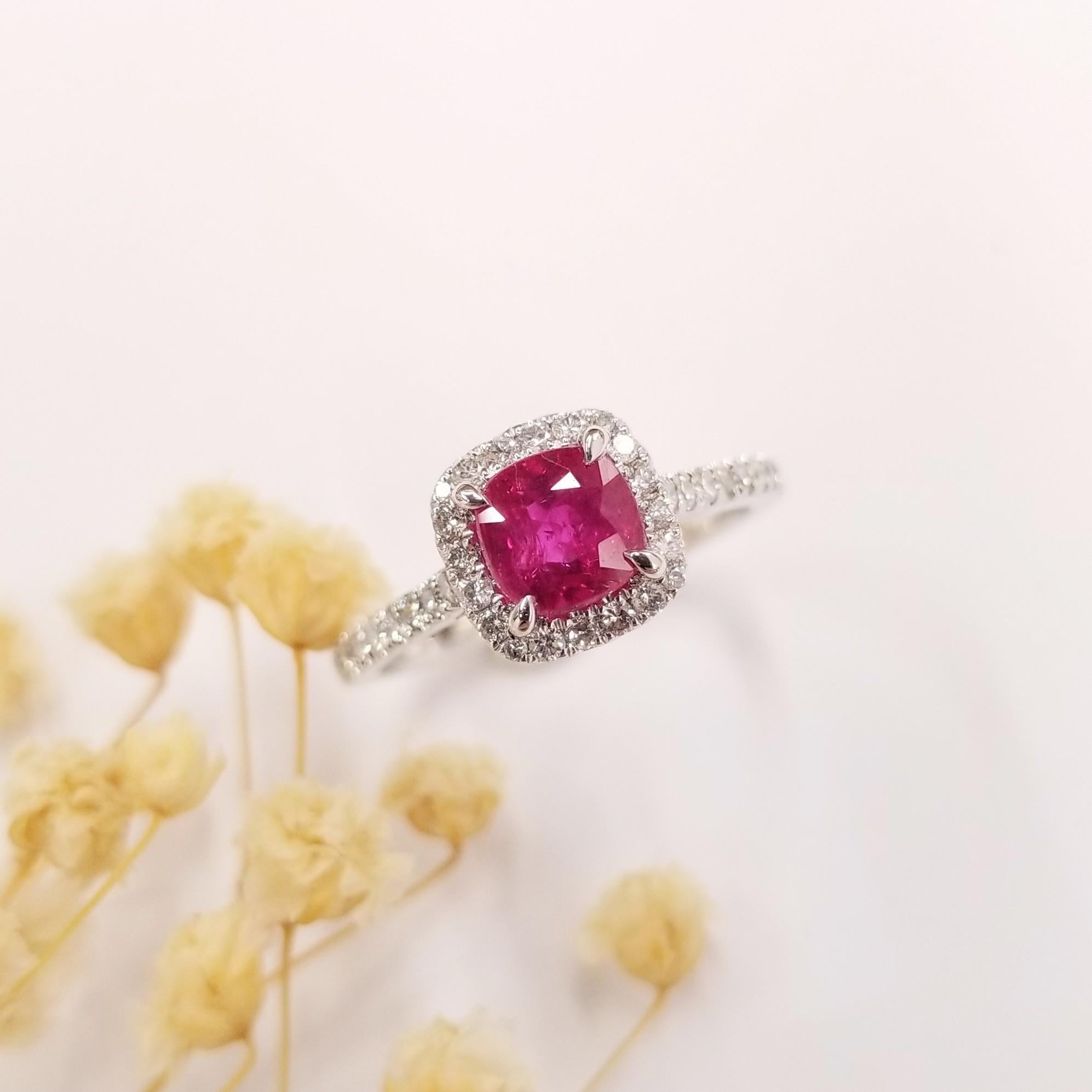 This exquisite ring is crafted in 18K White Gold, adding a touch of elegance and sophistication to any ensemble.

The center of attention is the breathtaking 1.26 Carat intense pink red natural ruby, skillfully cut in a cushion shape. This gemstone