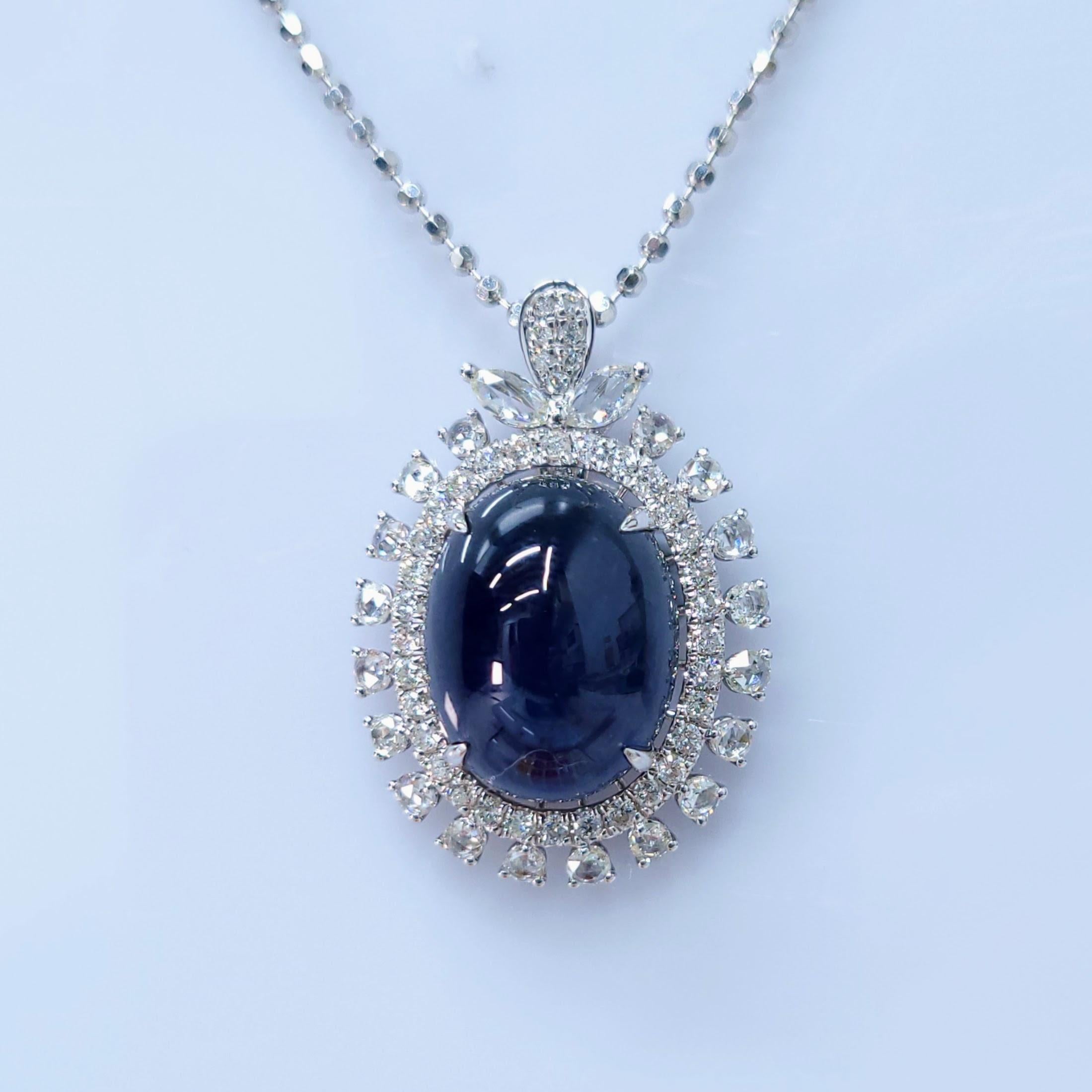 A Dazzling Display of Sapphire Elegance
This exquisite pendant features a stunning 13.31-carat oval cabochon-cut blue sapphire, a rare and highly sought-after gemstone. The sapphire's deep blue color and exceptional clarity are further enhanced by