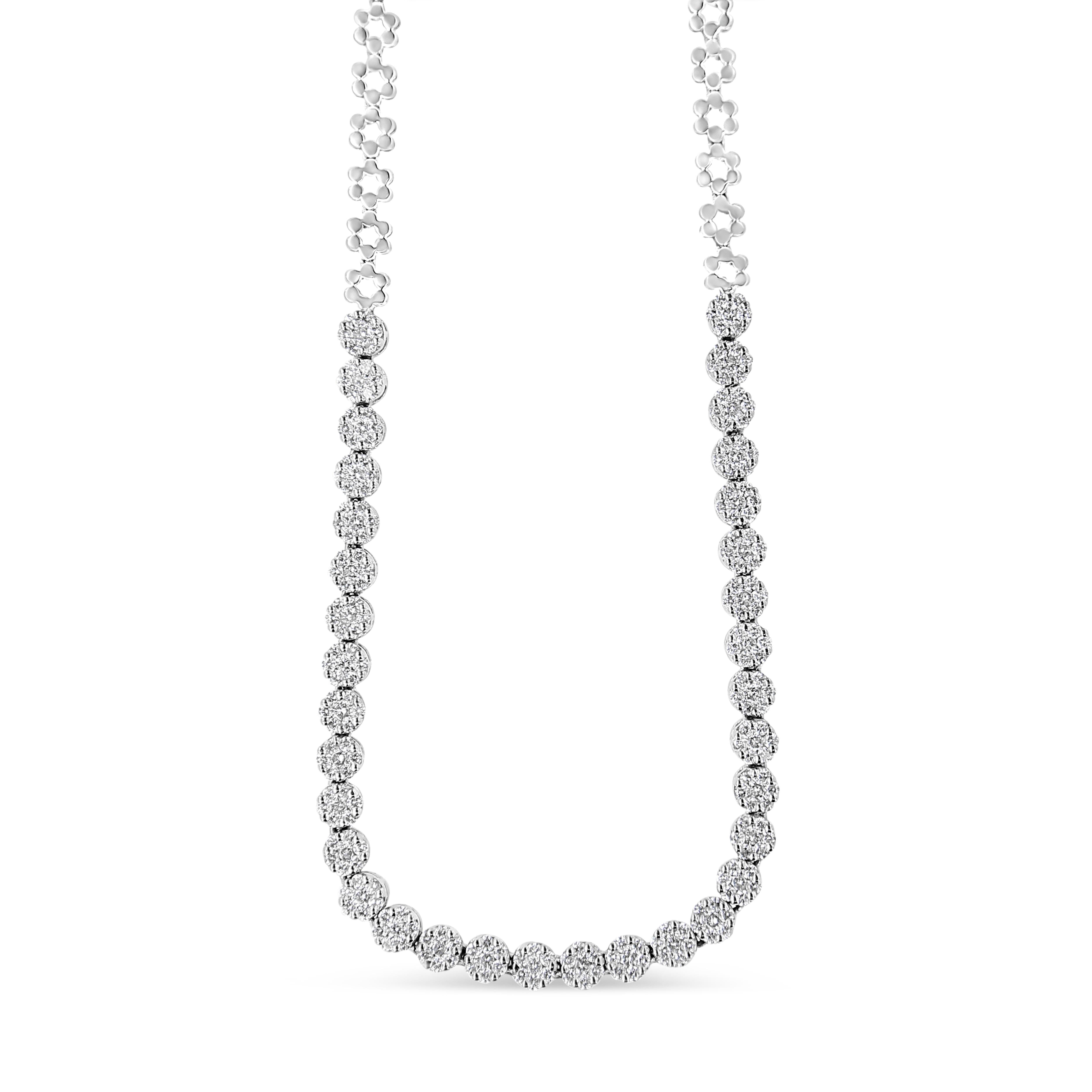 Aussi élégant que spectaculaire, cet éblouissant collier de diamants Riviera rehausse toutes les tenues. Réalisé de main de maître en or blanc 14 carats, ce modèle accrocheur présente des grappes de diamants ronds en forme de fleur, associés à des
