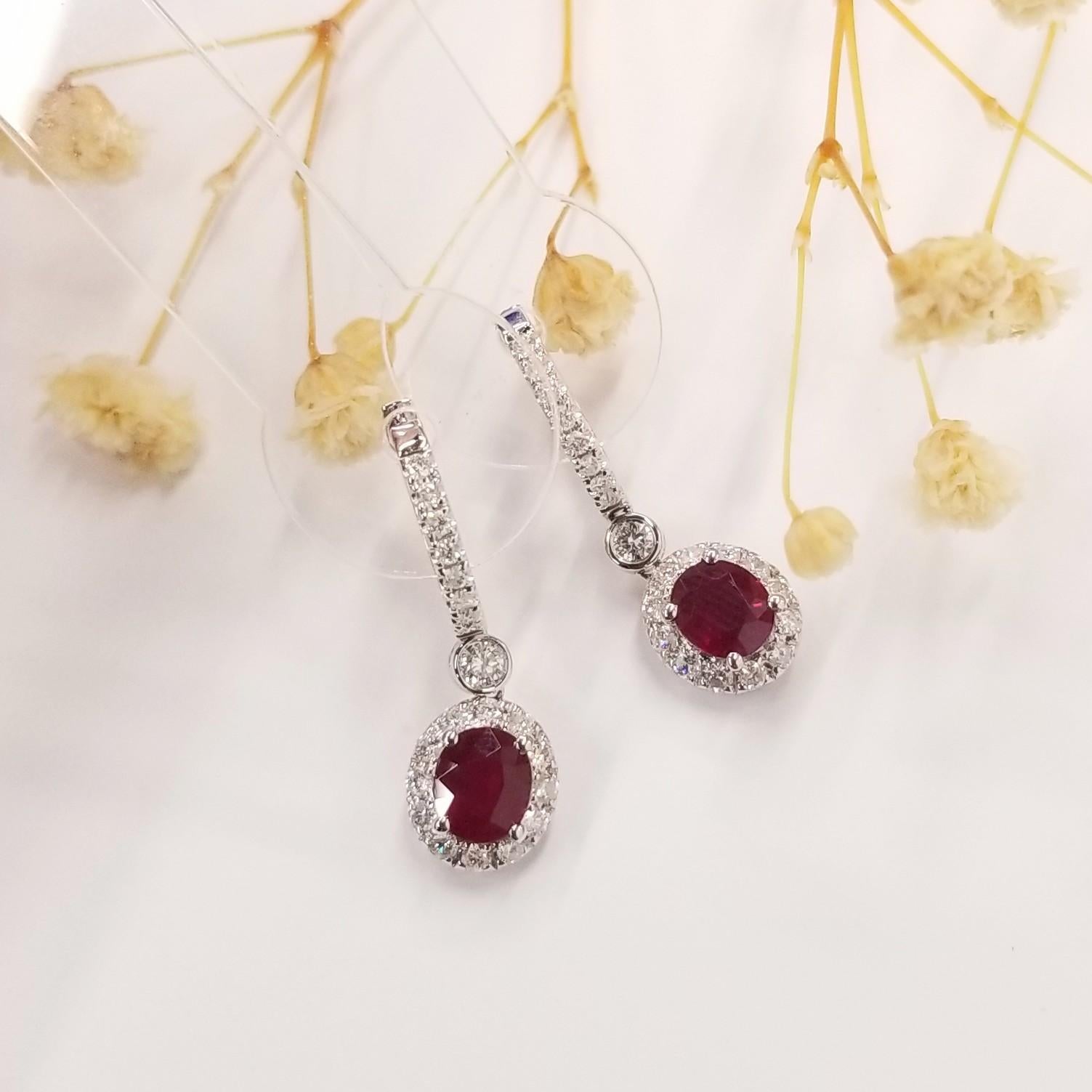 Introducing a captivating pair of IGI Certified 1.58 Carat Ruby Dangle Earrings, a truly mesmerizing composition that showcases the beauty of natural rubies and diamonds. Encased in 18K White Gold, these earrings are adorned with a deep red