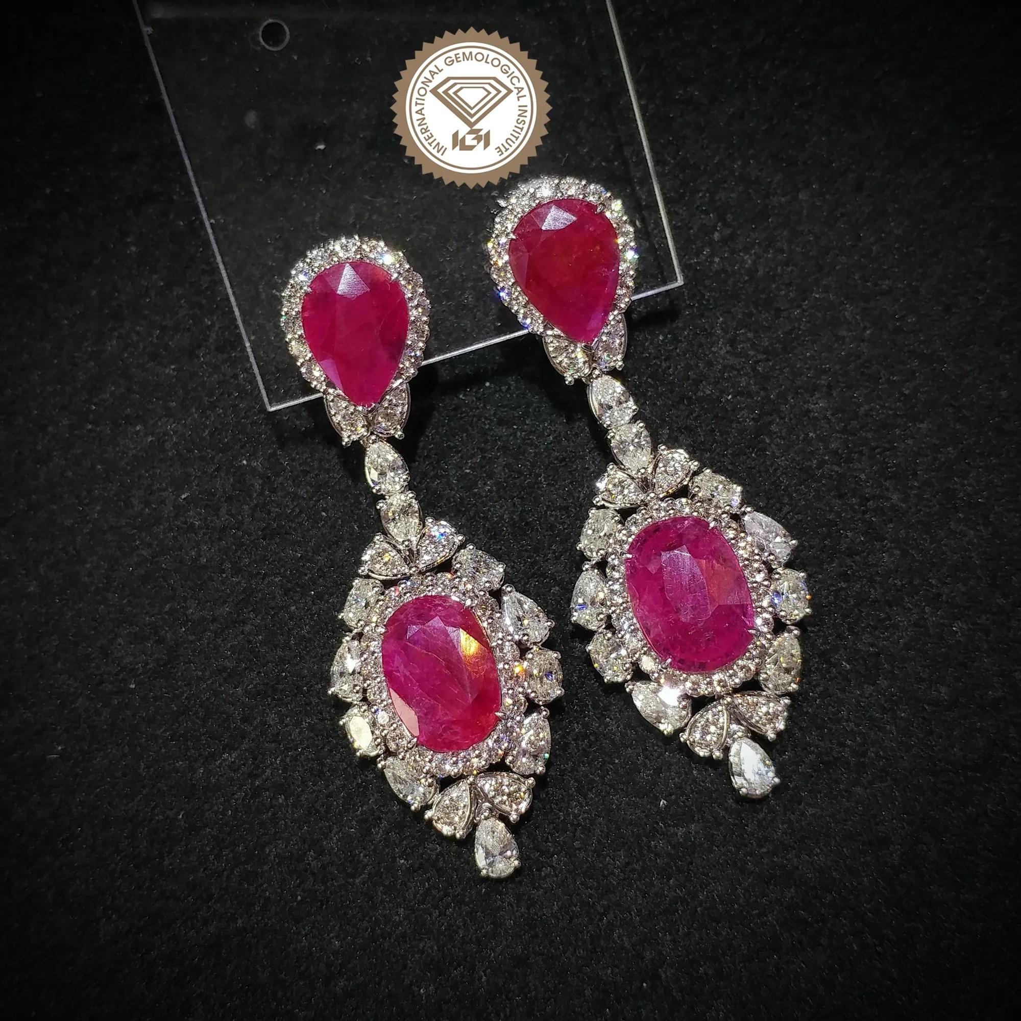 This extravagantly bold pair of earrings are not for the faint of heart! 1
6.74 carats of deep red  pear-shaped and oval-shaped rubies take center stage in these modern design drop earrings. The 6.86 carats of round,pear and oval cut white diamonds