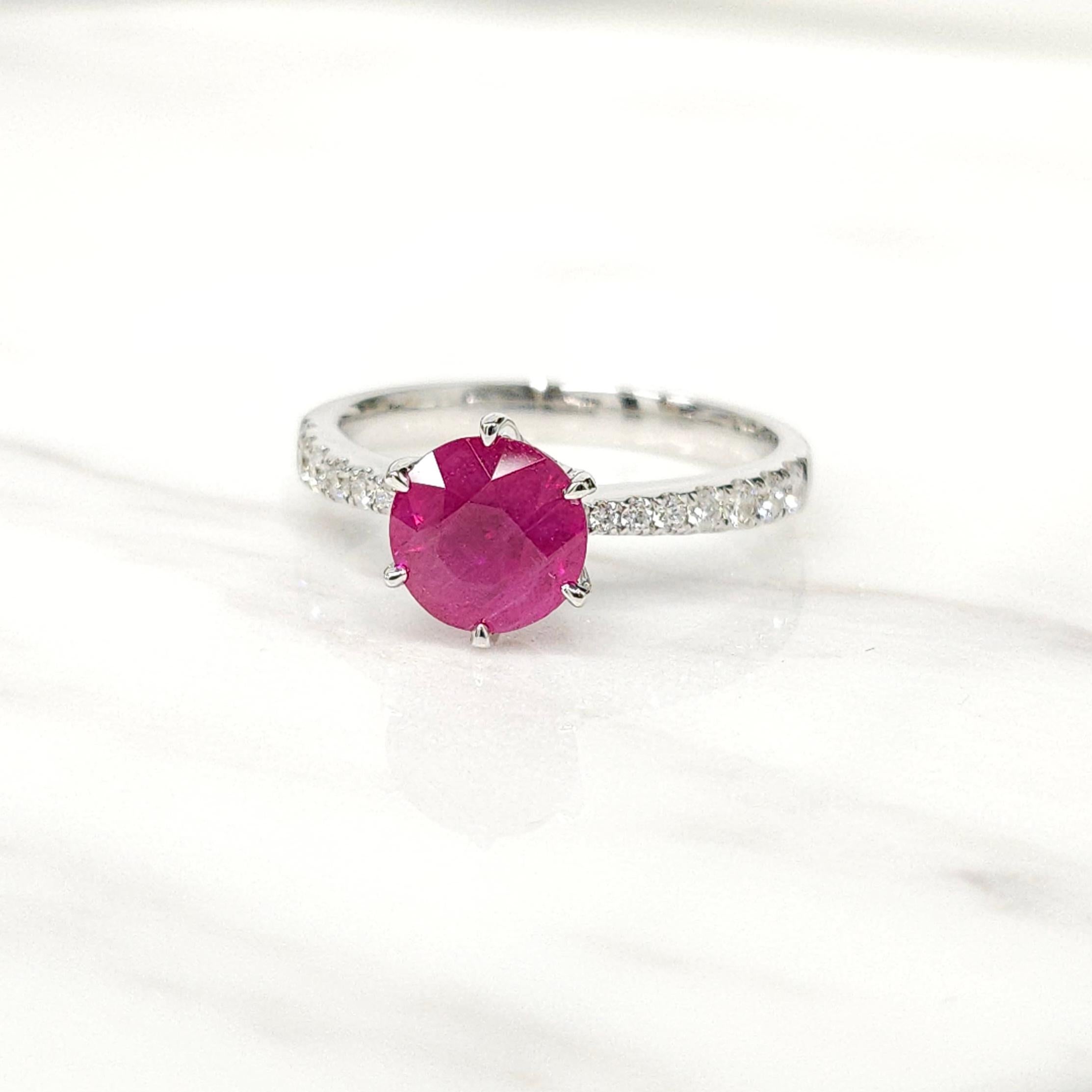 Experience the allure of this IGI Certified 1.70 Carat Ruby in an intense pinkish purplish red color, encased in an elegant 6-prong setting with exquisite natural diamonds, all set in a classic 18K white gold ring. The timeless beauty of this piece