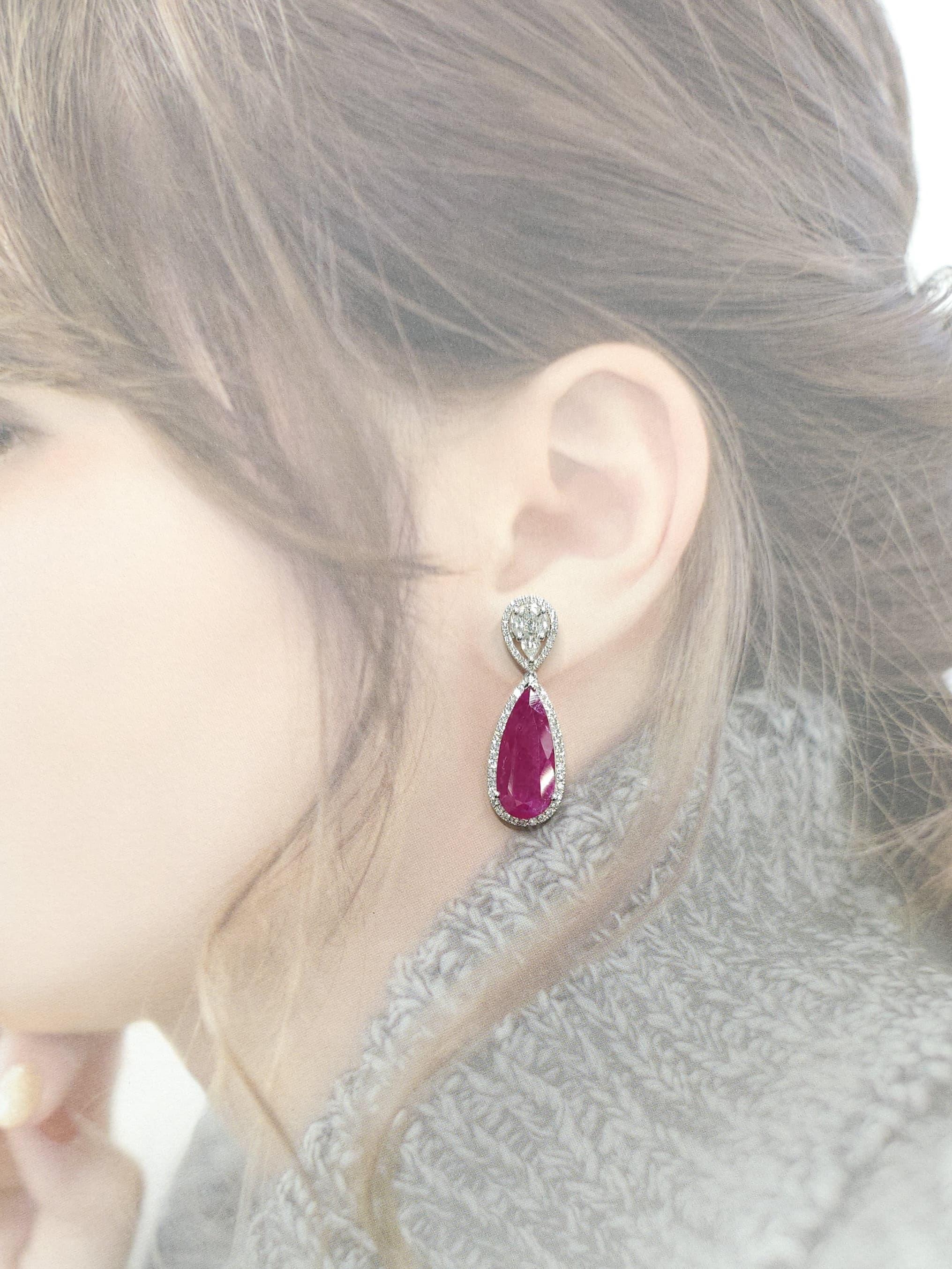 Indulge in extravagance with these breathtaking dangling earrings that exude opulence and grandeur. Featuring a stunning IGI Certified 18.49 Carat Burma Ruby, with two pear-shaped rubies approximately 9.66 and 8.83 carats respectively, in an intense