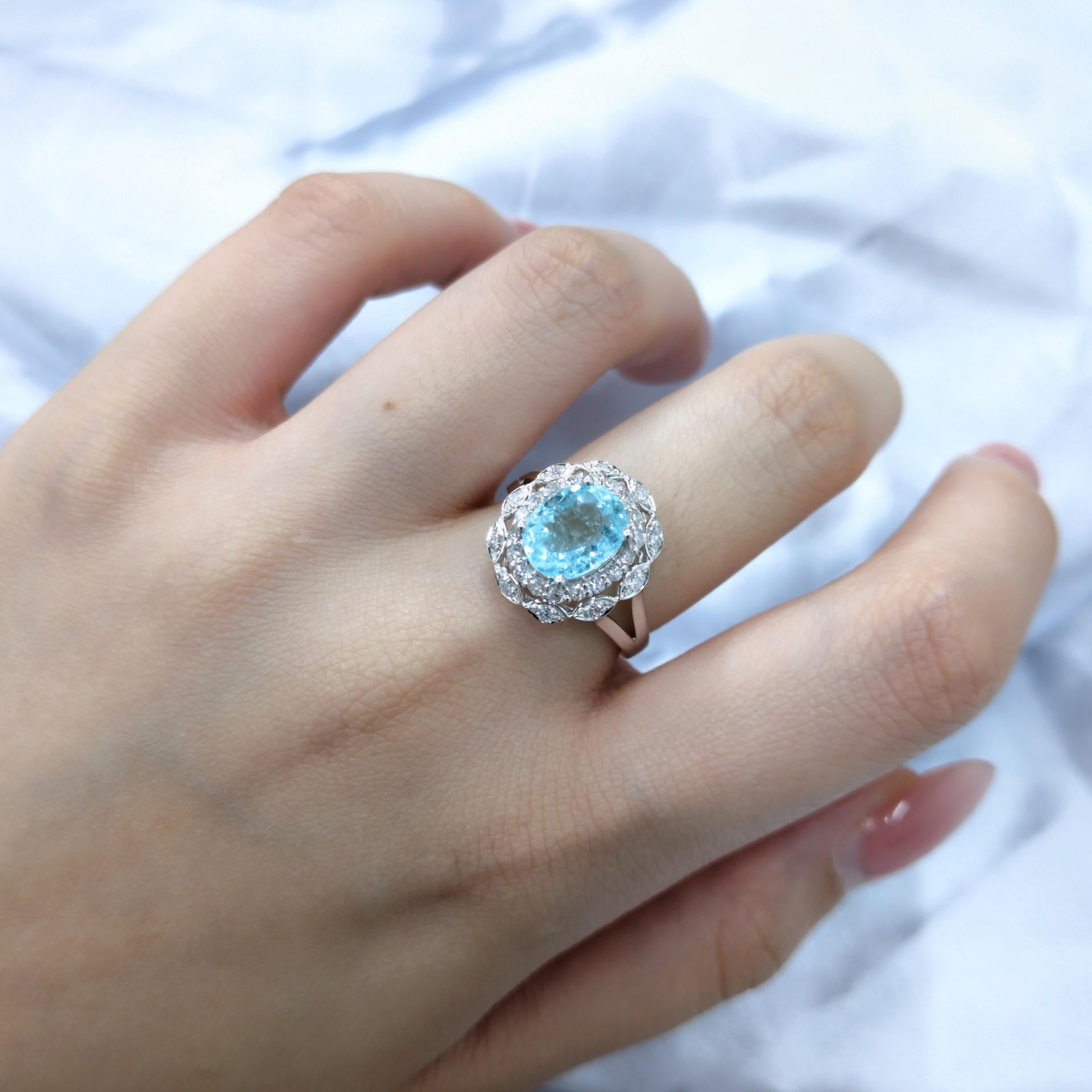 This exquisite ring features a stunning 1.85-carat Paraiba tourmaline, a rare and highly sought-after gemstone known for its vibrant neon blue-green color. The tourmaline is set in a classic oval shape, enhancing its brilliance and