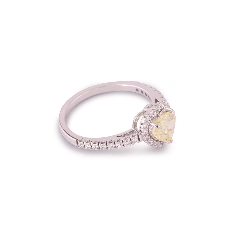 Crafted in 2.60 grams of 18-karat White Gold, The Indsi Ring contains 36 Stones of Round Diamonds with a total of 0.26-Carats in G-H Color and VVS-VS Clarity combined 1 Stone of Heart Diamond with a total of 0.93-Carats in Fancy Yellow Color and I1