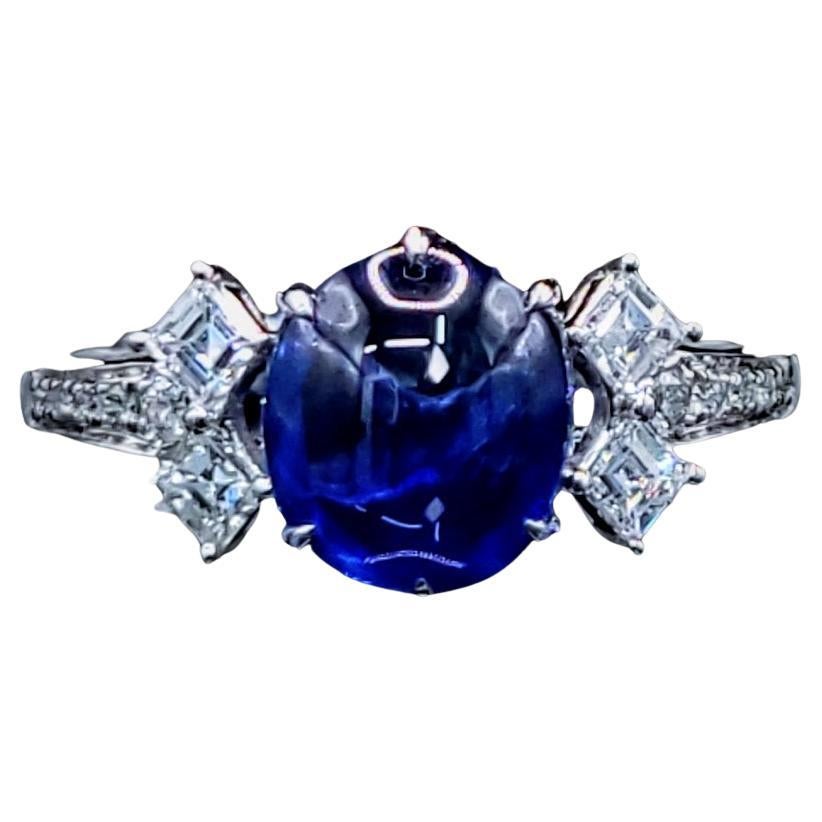 Discover the captivating allure of this exquisite ring, showcasing a magnificent 2.02-carat oval cabochon sapphire of a truly intense blue hue. This vibrant and captivating color evokes the depths of the ocean and the brilliance of a summer sky,