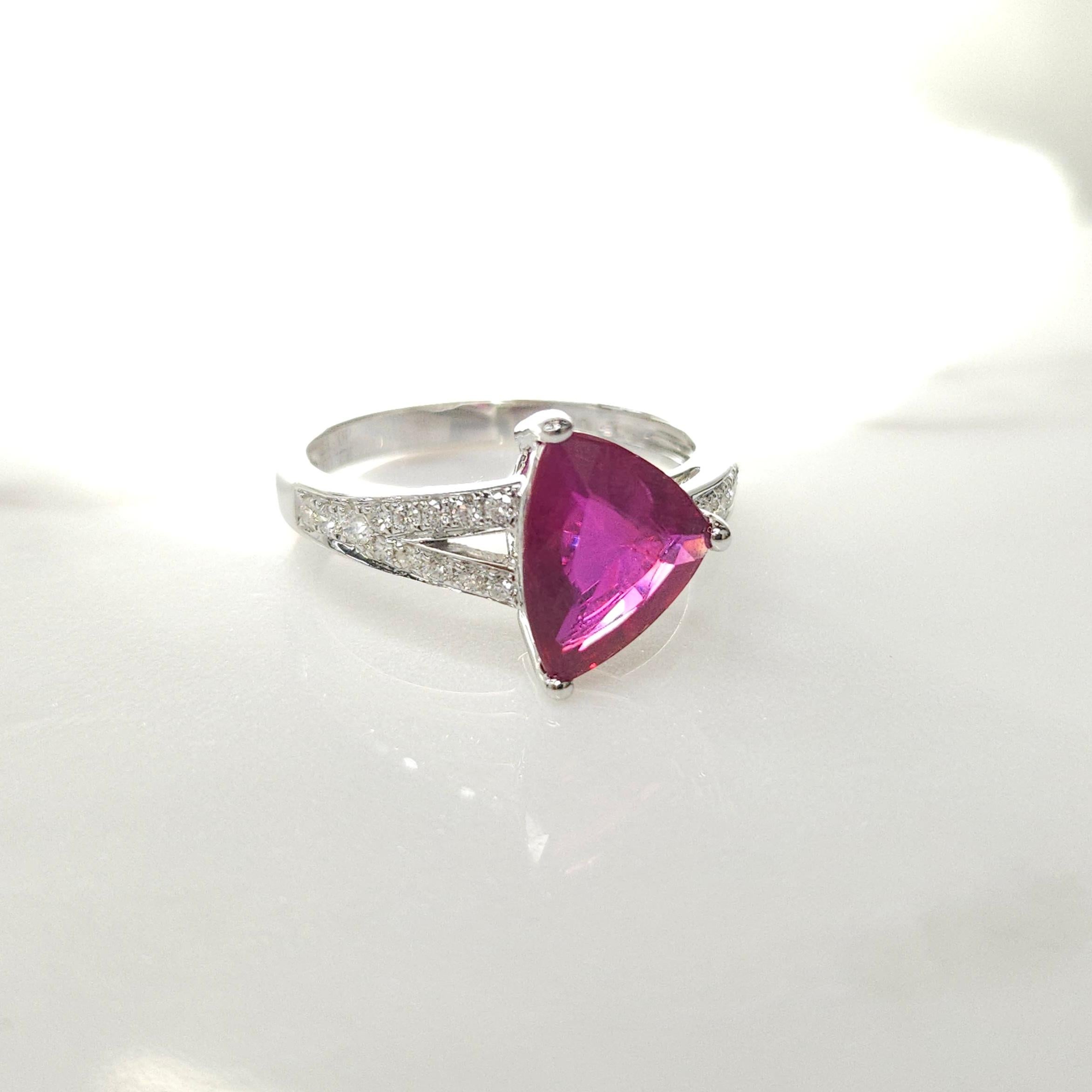 Step into the world of sophistication and elegance with this stunning cocktail-style ring featuring an IGI Certified 2.09 Carat ruby in an intense purplish-red hue, expertly crafted into a unique and dazzling triangular shape that captivates the eye