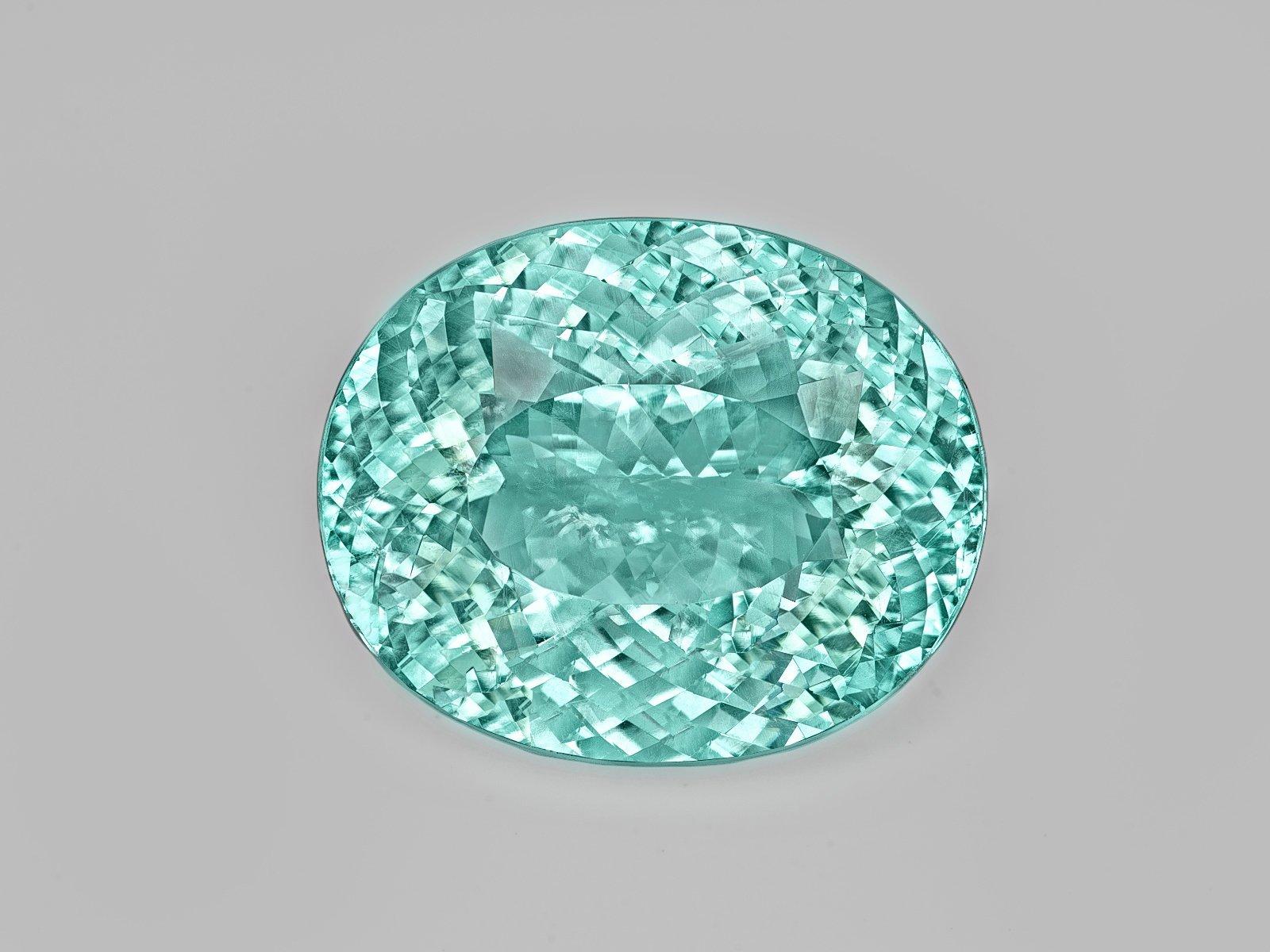 A stunning 22 carat Paraiba tourmaline displays its brilliant aqua color in this amazing ring. Paraiba tourmalines are among the most valuable gemstones in the world, and this stone exhibits the signature neon green color seen only in the finest