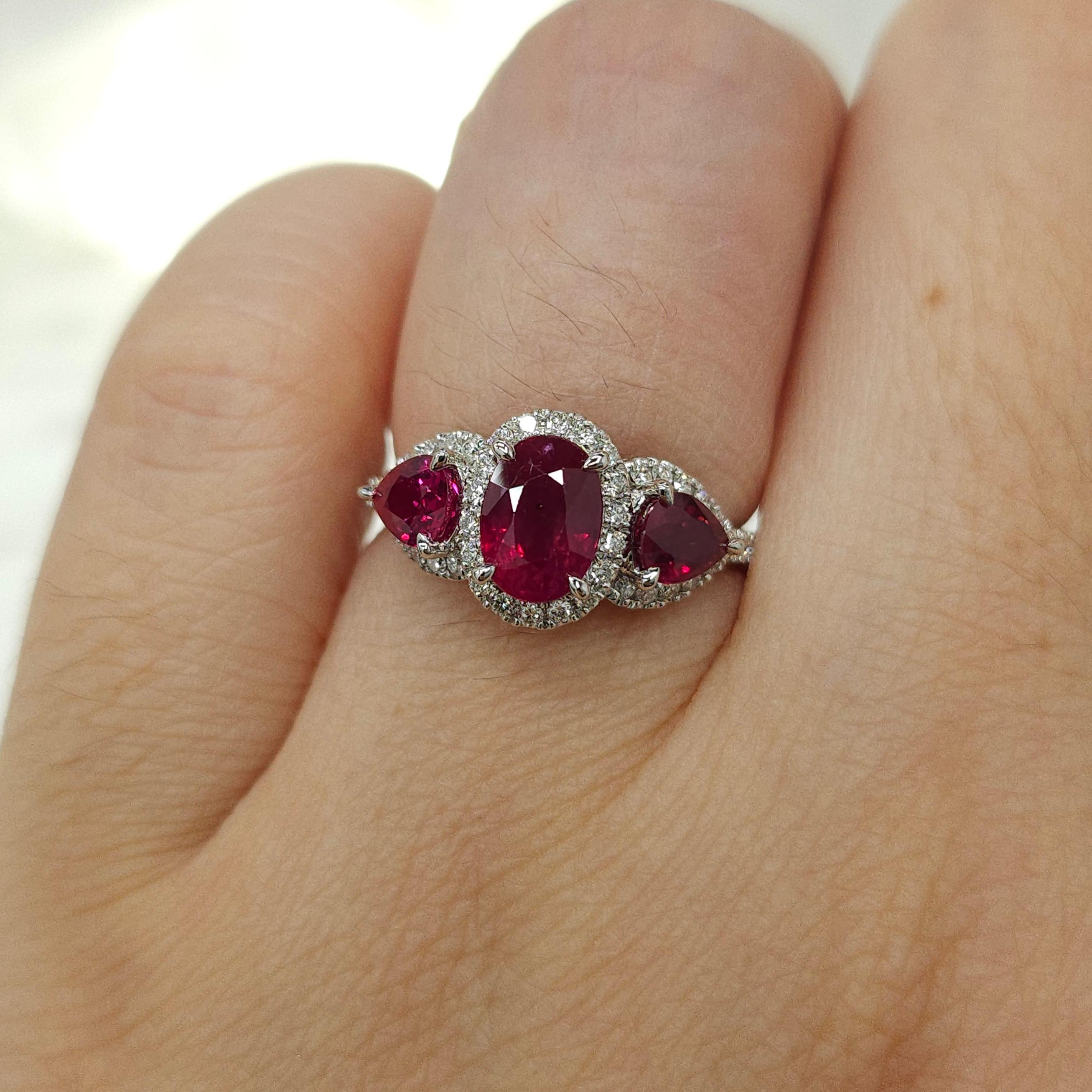 Prepare to be enchanted by the extraordinary IGI certified 18K white gold ring featuring a stunning 1.38ct oval-shaped ruby, accompanied by two pear-shaped rubies totaling 0.84ct, and 0.29ct of sparkling round brilliant cut natural diamonds.

The