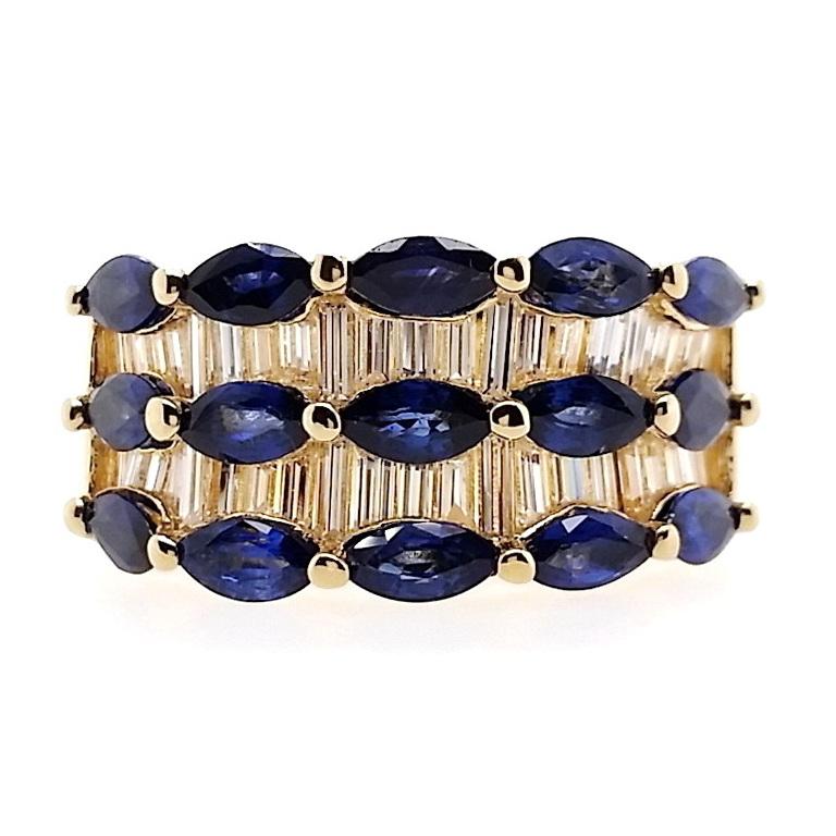 Cette bague en or jaune 18 carats, ornée de saphirs taillés en marquise dans des tons bleus vifs à profonds, est d'une allure éternelle. Le contraste captivant prend vie grâce à l'éclat des diamants étincelants de taille baguette, faisant de cette