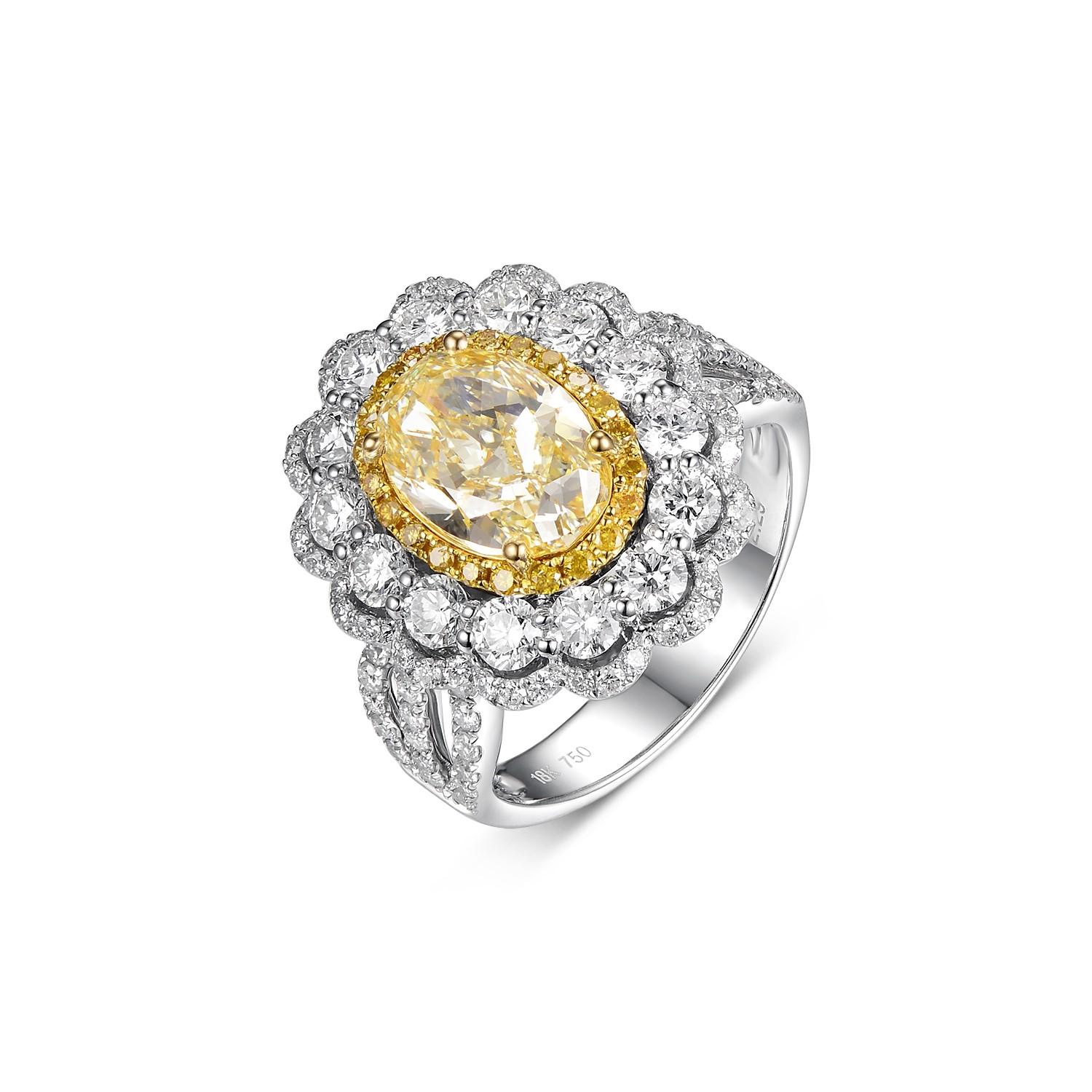 Cette grande et belle bague présente un diamant naturel de 2,29 carats de taille ovale, de couleur N VS1, serti dans un double halo ovale en or blanc et jaune 18 carats, avec une tige fendue. La pierre principale est accompagnée d'un diamant jaune