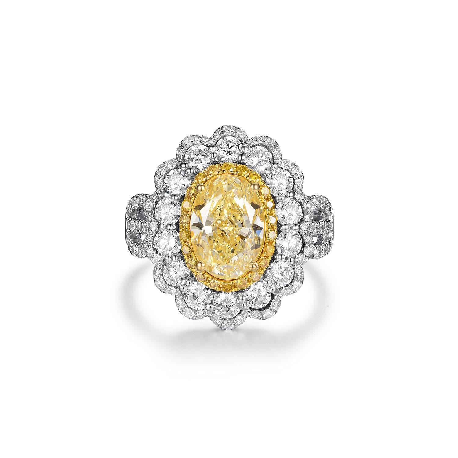 This exquisite ring features a central yellow diamond, IGI certified and weighing 2.29 carats with an N color grading, which exhibits a warm, sunlit hue. Set in 18 karat white gold, this resplendent gemstone is the star of a triple halo setting, a