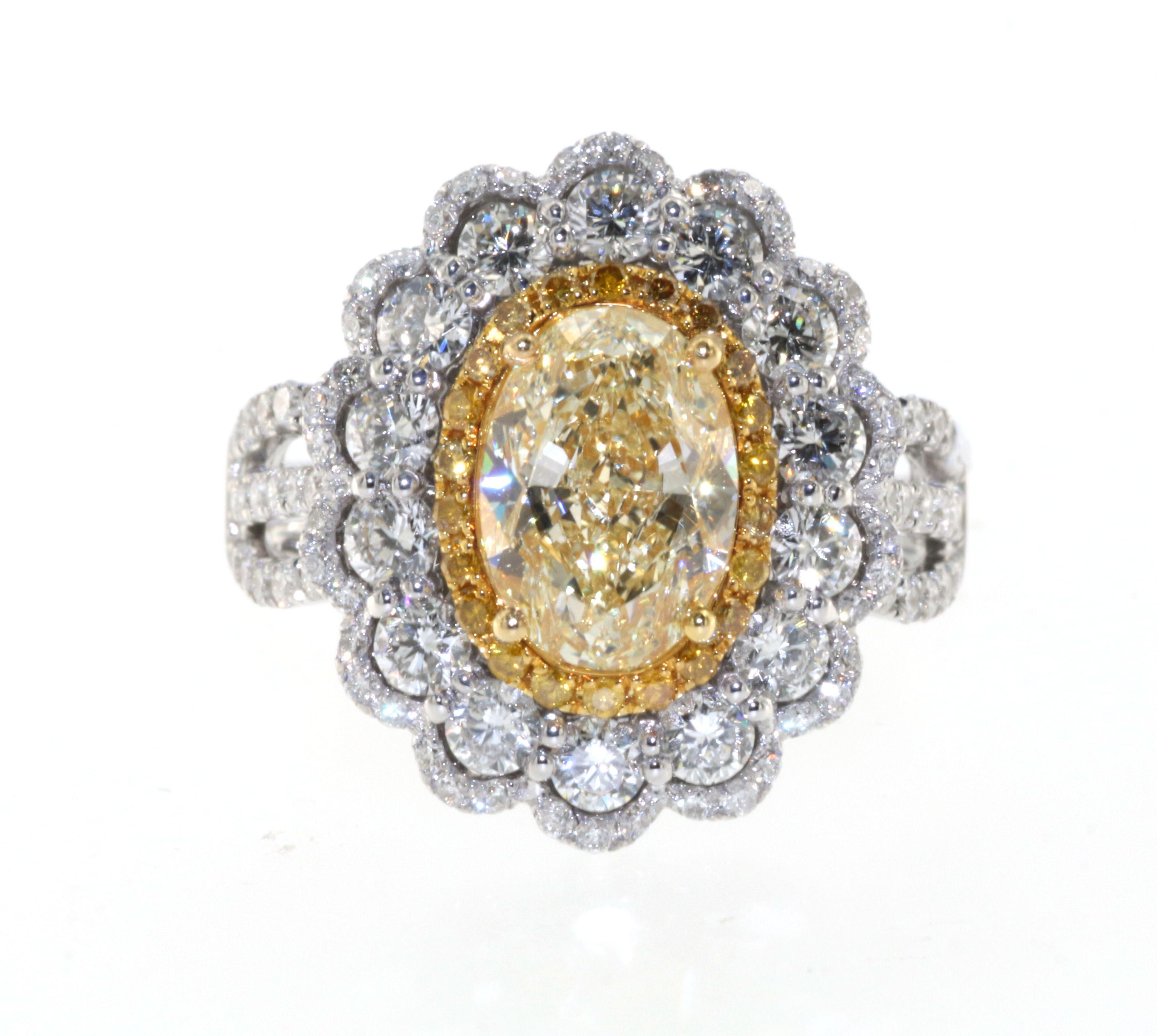 Oval Cut IGI Certified 2.29 Carats N Color Yellow Diamond in 18 Karat Triple Halo Ring For Sale