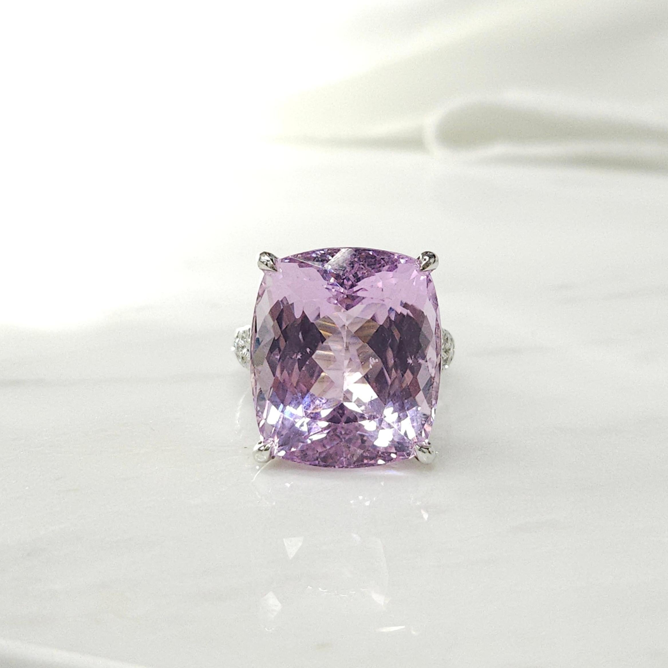 This stunning cocktail ring features an IGI Certified 24.20 Carat Kunzite in an intense purplish pink color and cushion shape, set in 18K white gold. The vibrant Kunzite gemstone is complemented by 30 white round brilliant diamonds totaling 0.47