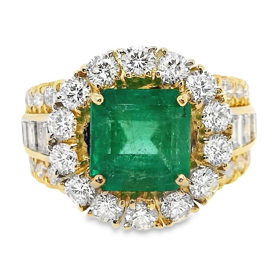 Immerse yourself in luxury of our Top Crown Jewelry new collection, with our 18K yellow gold ring, featuring a captivating emerald-cut Colombian emerald weighing 2.71 carats. The intense green hue of the emerald is complemented by 2.76 carats of