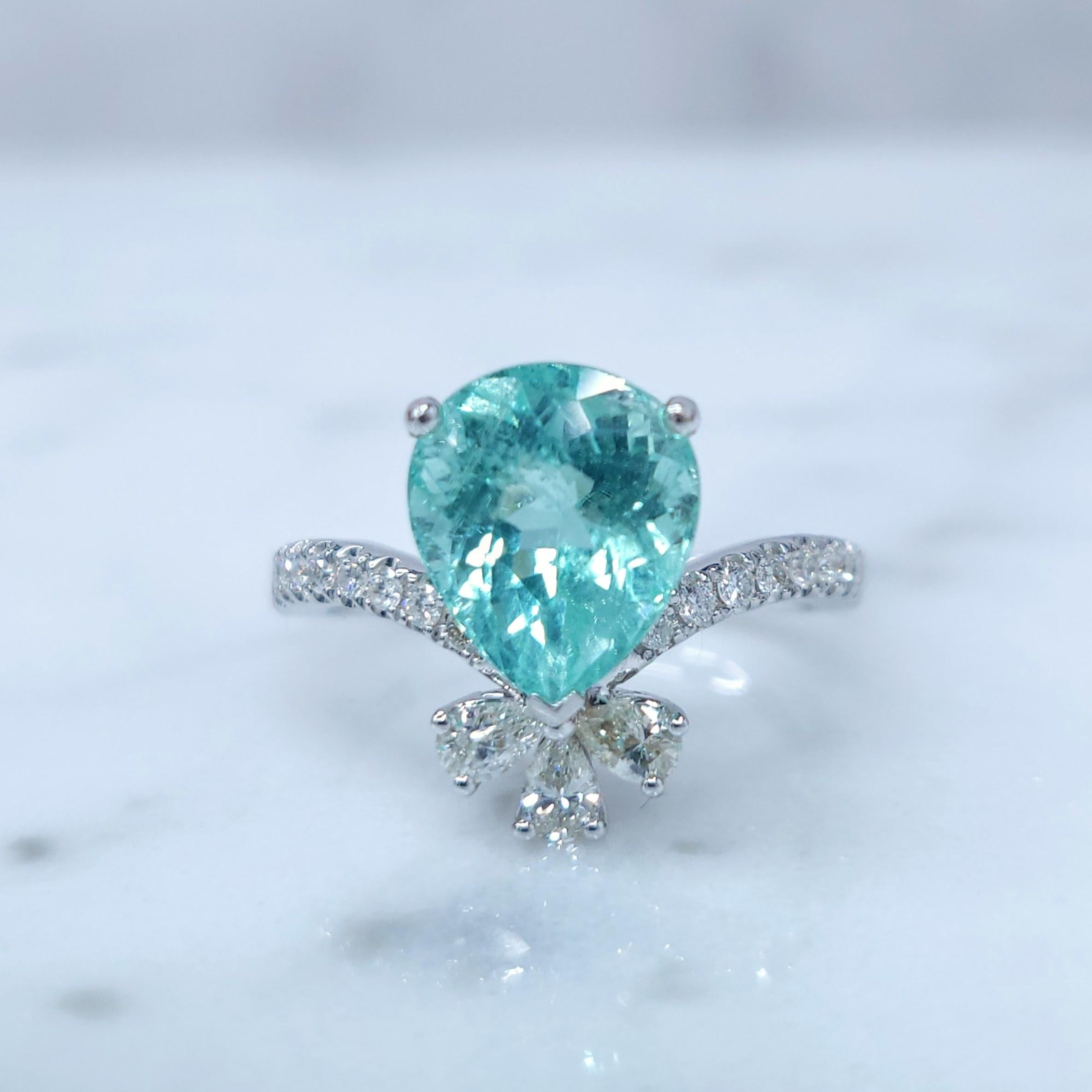 This extraordinary ring showcases a mesmerizing 2.93-carat Paraiba tourmaline, a gemstone renowned for its vivid neon blue-green color. The stone is meticulously set in a classic pear shape, allowing its brilliance to shine.

Above the tourmaline,