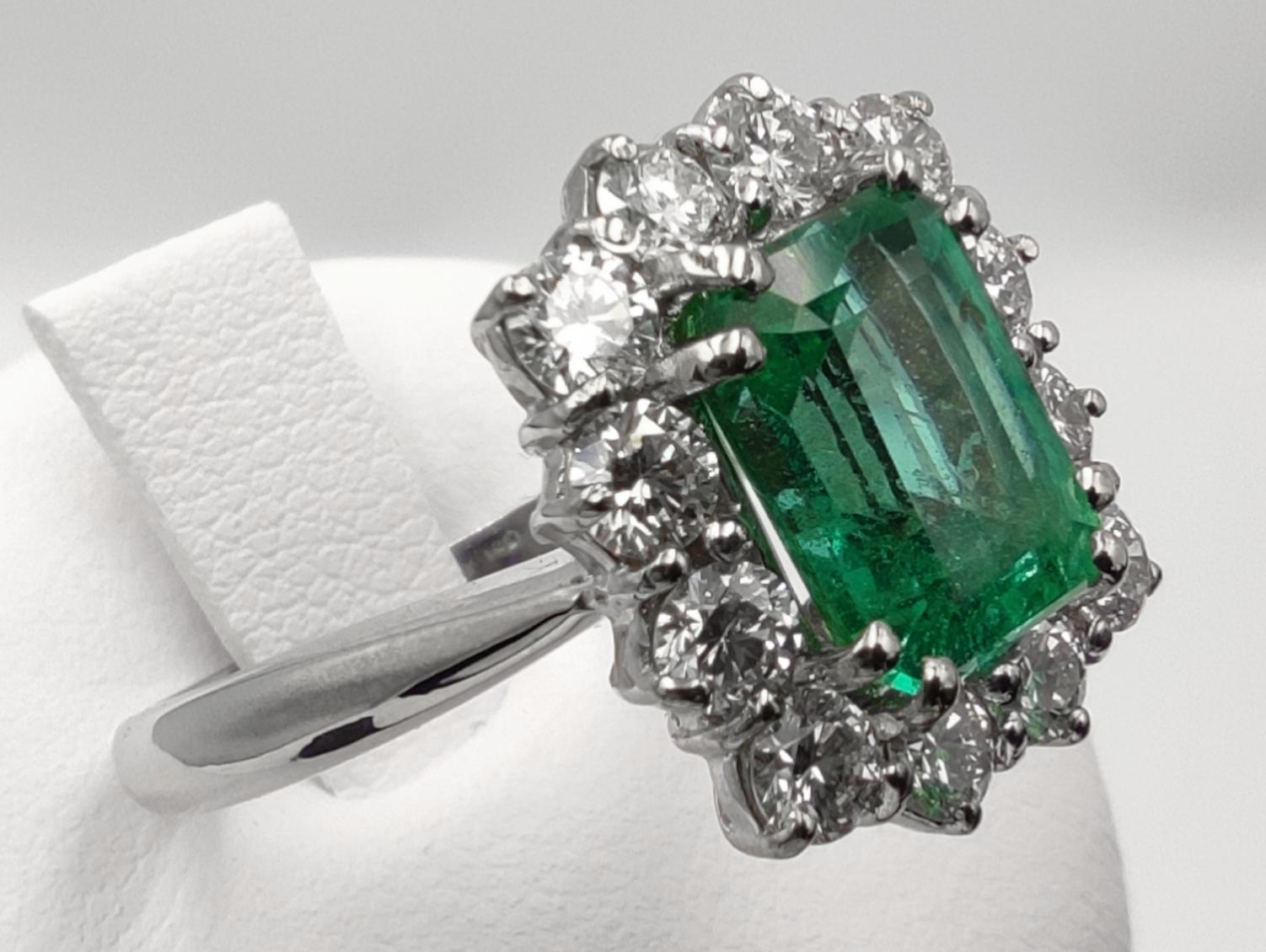 White gold ring with IGI certified minor oil 2.20 carat emerald and diamond halo.
