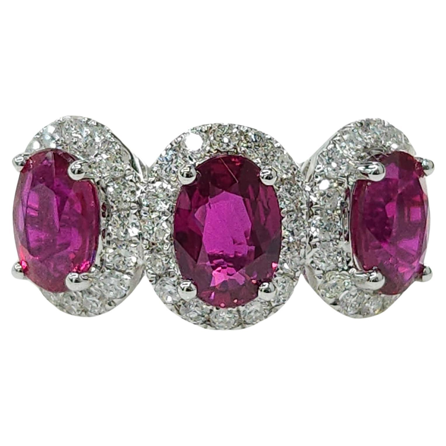 Prepárate para dejarte cautivar por el extraordinario anillo de oro blanco de 18 quilates con certificado IGI, que incluye un deslumbrante trío de rubíes birmanos de forma ovalada y un reluciente halo de diamantes.

En el corazón de este exquisito