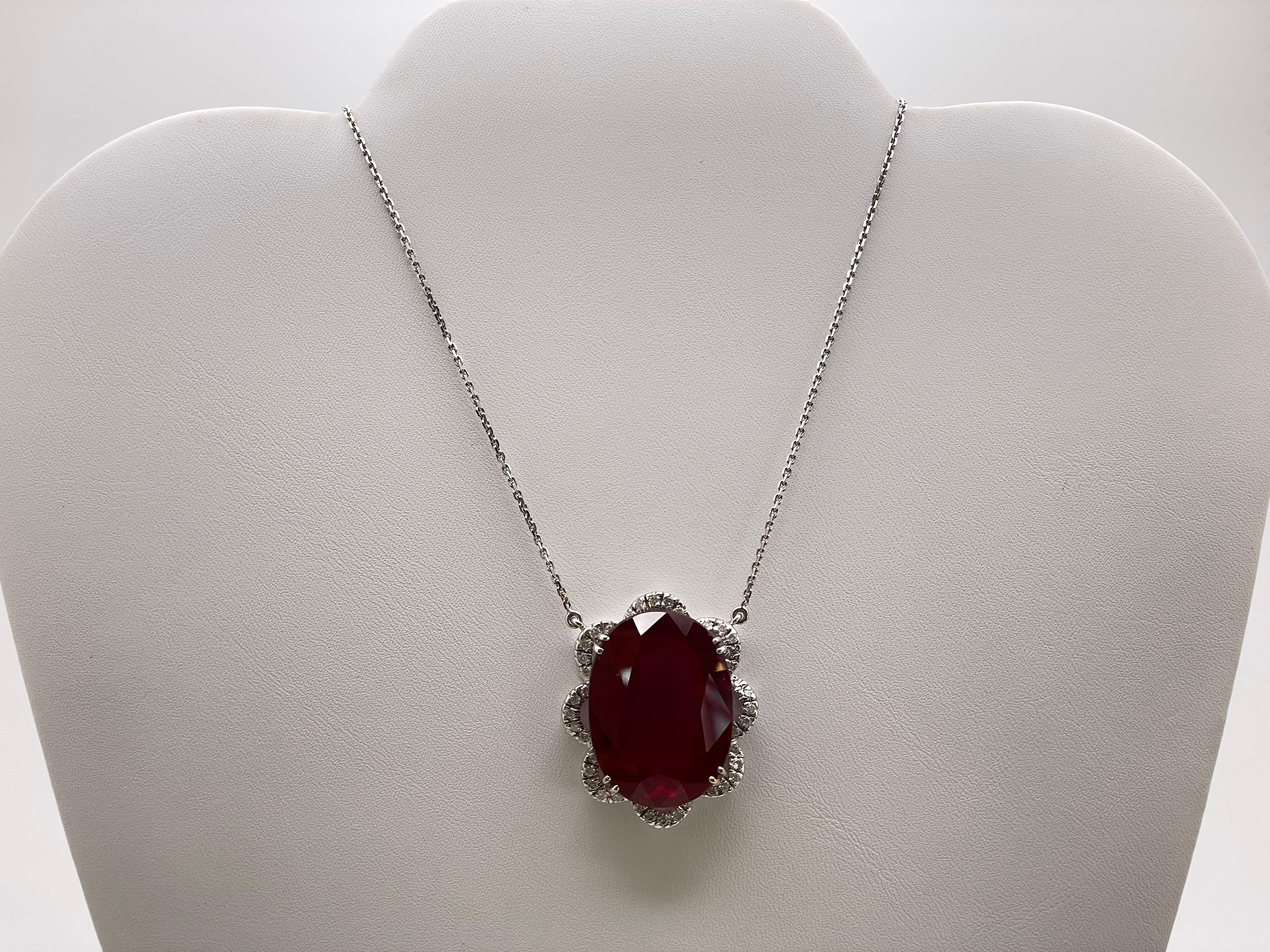An incredible IGI certified 18K white gold ruby diamond pendant. Centered with a massive, gorgeous lab grown red corundum ruby weighing approximately 32 CT and measuring 27 x 20 x 9.75 mm, resting in a custom made 18K white gold setting. Accented